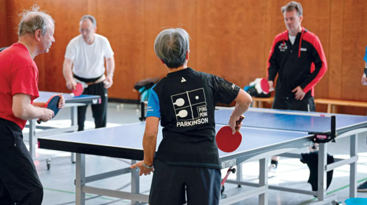مجموعة من المصابين بباركنسون  يمارسون تنس الطاولة (ا.ف.ب)