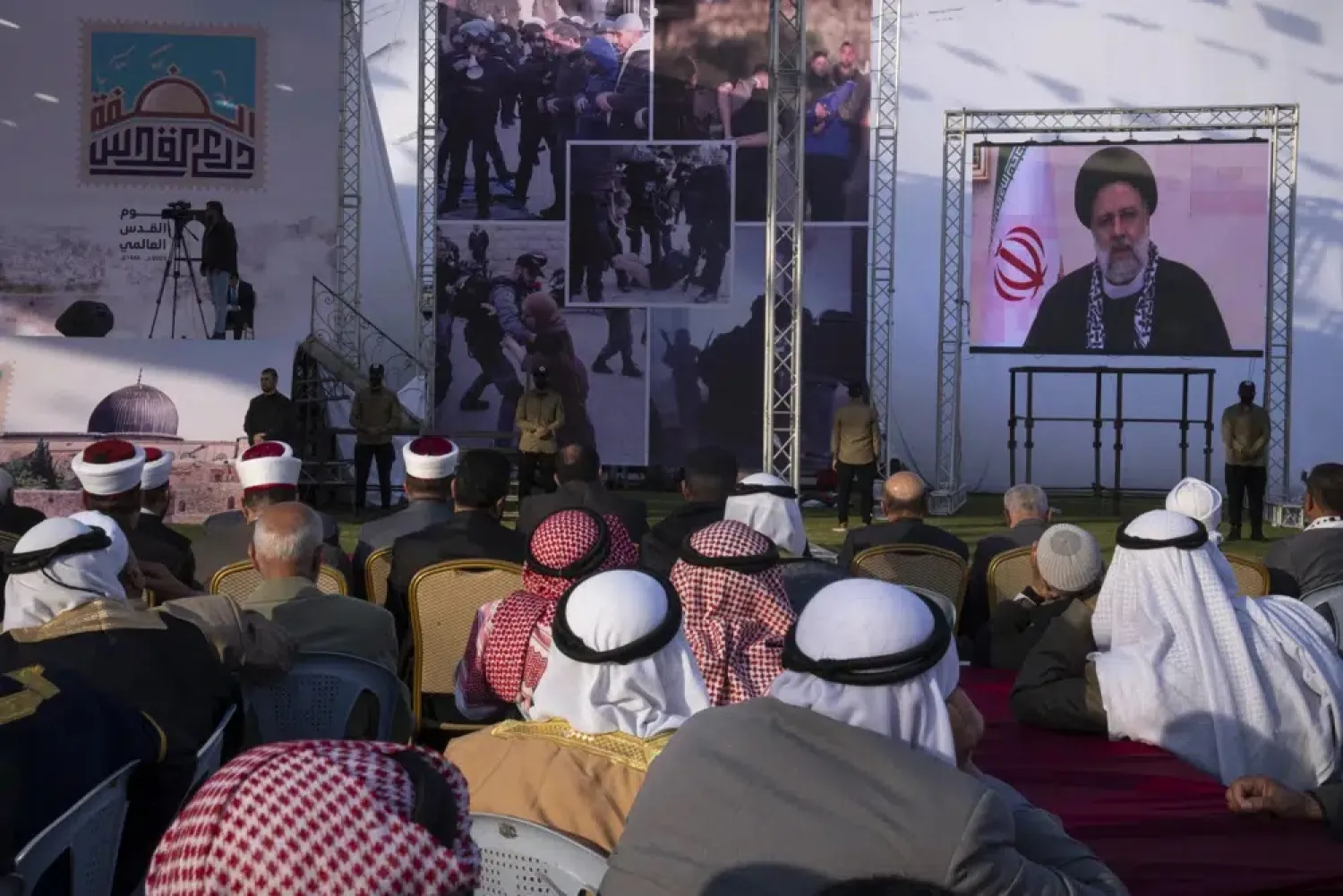 Palestinians watch a pre-recorded speech by Iranian President Ebrahim Raisi on "Jerusalem Day," which is called al-Quds Day after the city's Arabic name, at a soccer field in Gaza City, Friday, April 14, 2023. (AP Photo/Fatima Shbair)

