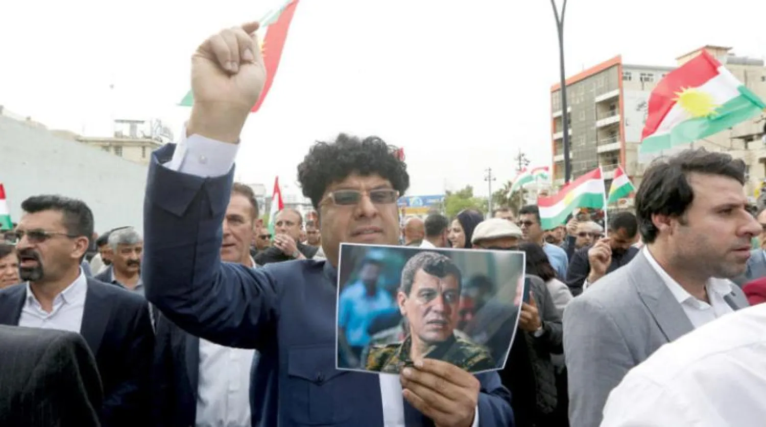 A Kurdish citizen holds a picture of Abdi during a protest after the assassination attempt in Sulaymaniyah on Apr. 9 (Reuters)