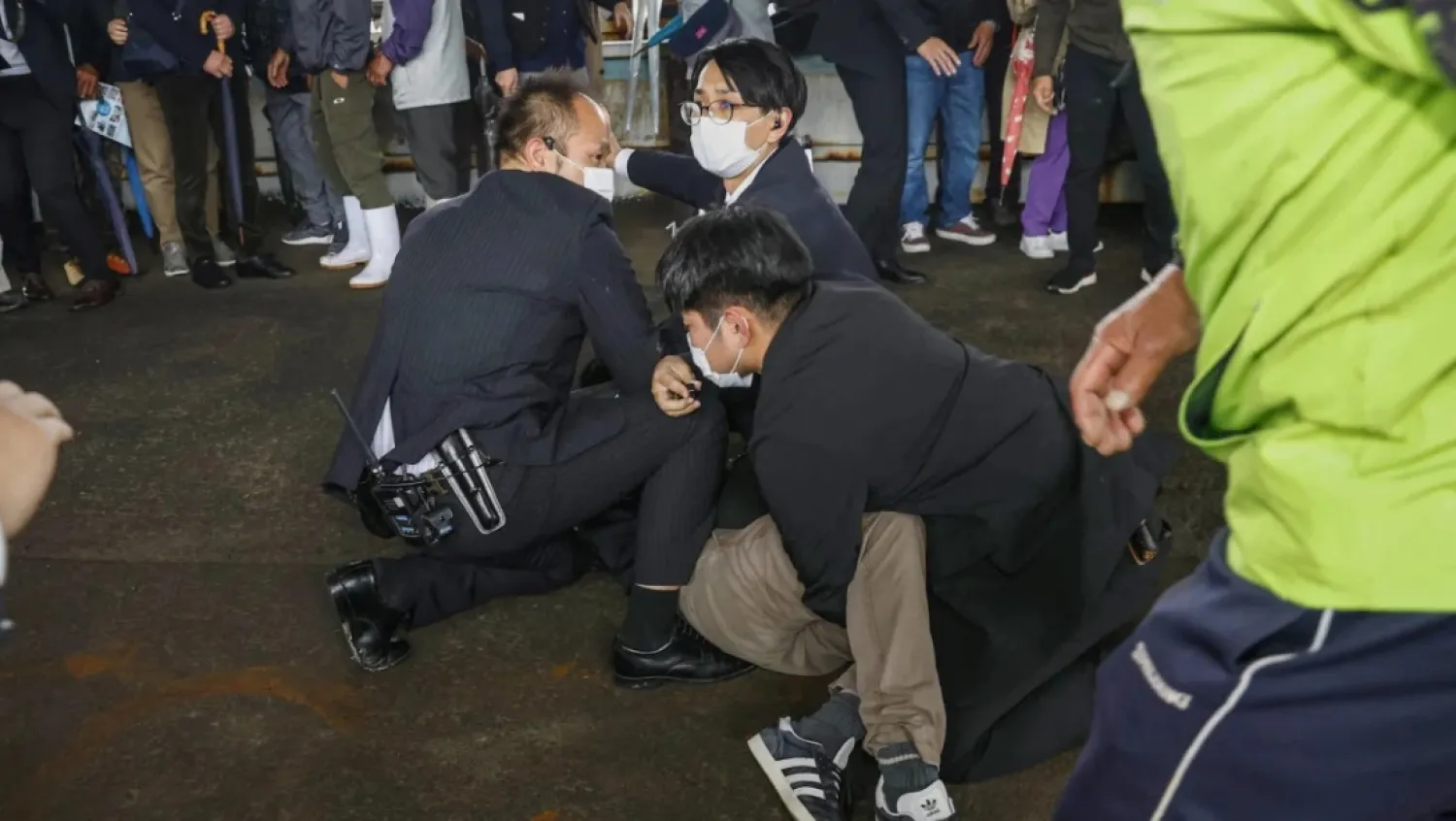 A man is held by police officers after an object was thrown near Japanese Prime Minister Fumio Kishida during a speech in Wakayama, Japan, on April 15, 2023. Reuters