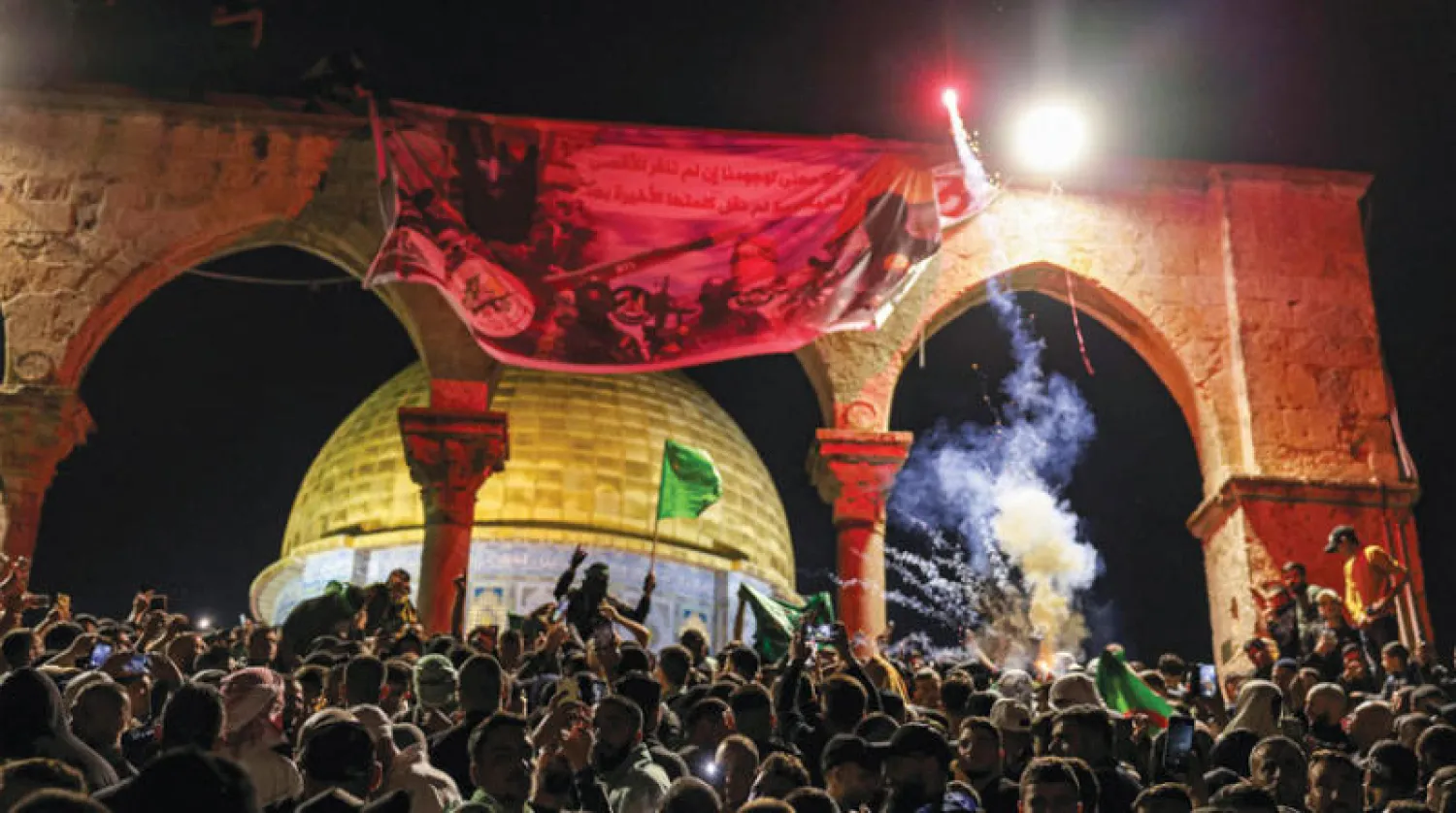 إطلاق شعلة مضيئة أثناء تجمع المصلين المسلمين في المسجد الأقصى ليلة 27 رمضان (أ.ف.ب)