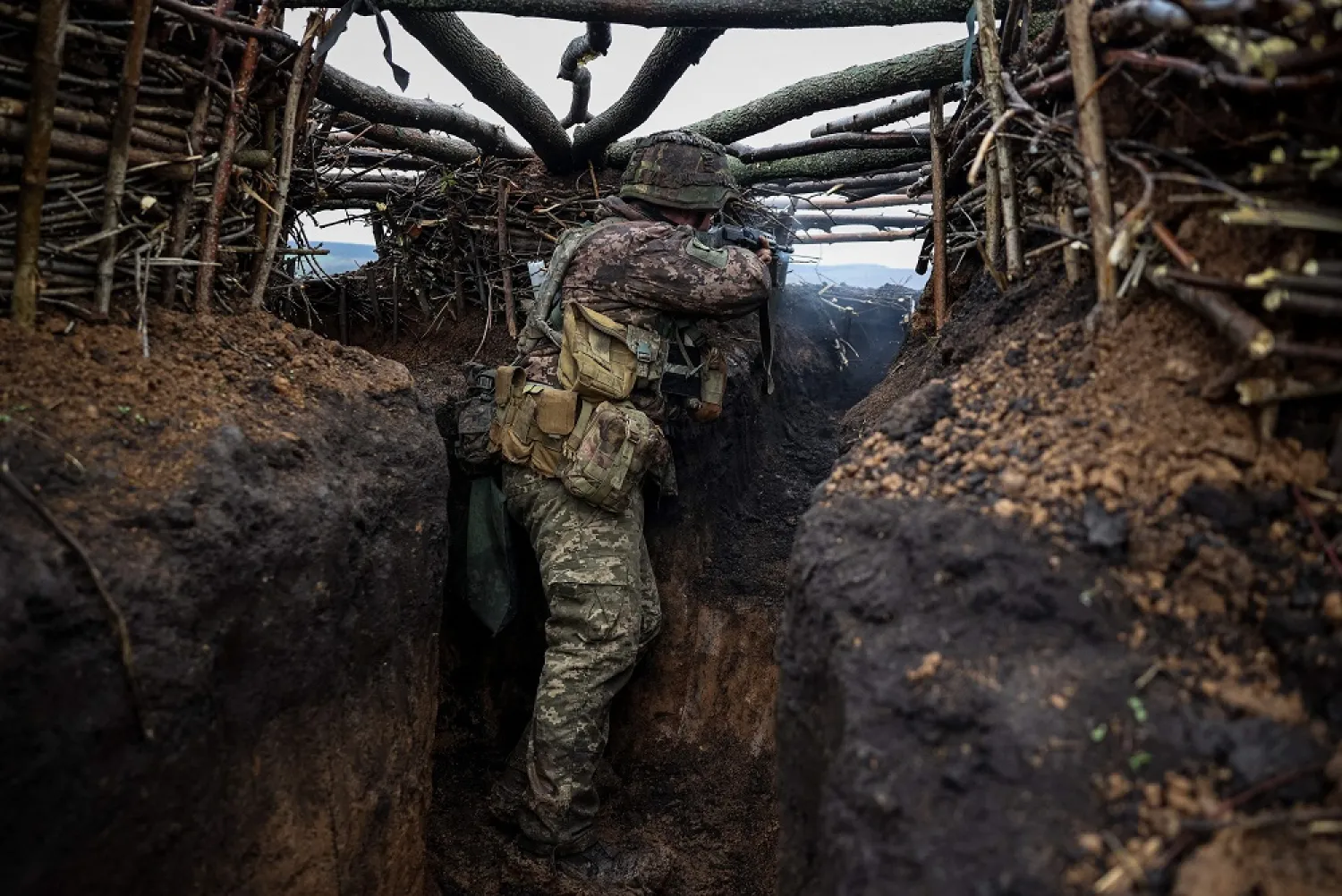 A Ukrainian infantryman of the 57th Separate Motorized Infantry Brigade "Otaman Kost Khordienko" fires an assault rifle at enemy positions from a trench at an undisclosed location near the town of Bakhmut, Donetsk region, eastern Ukraine, on April 13, 2023, amid the Russian invasion of Ukraine. (AFP) 