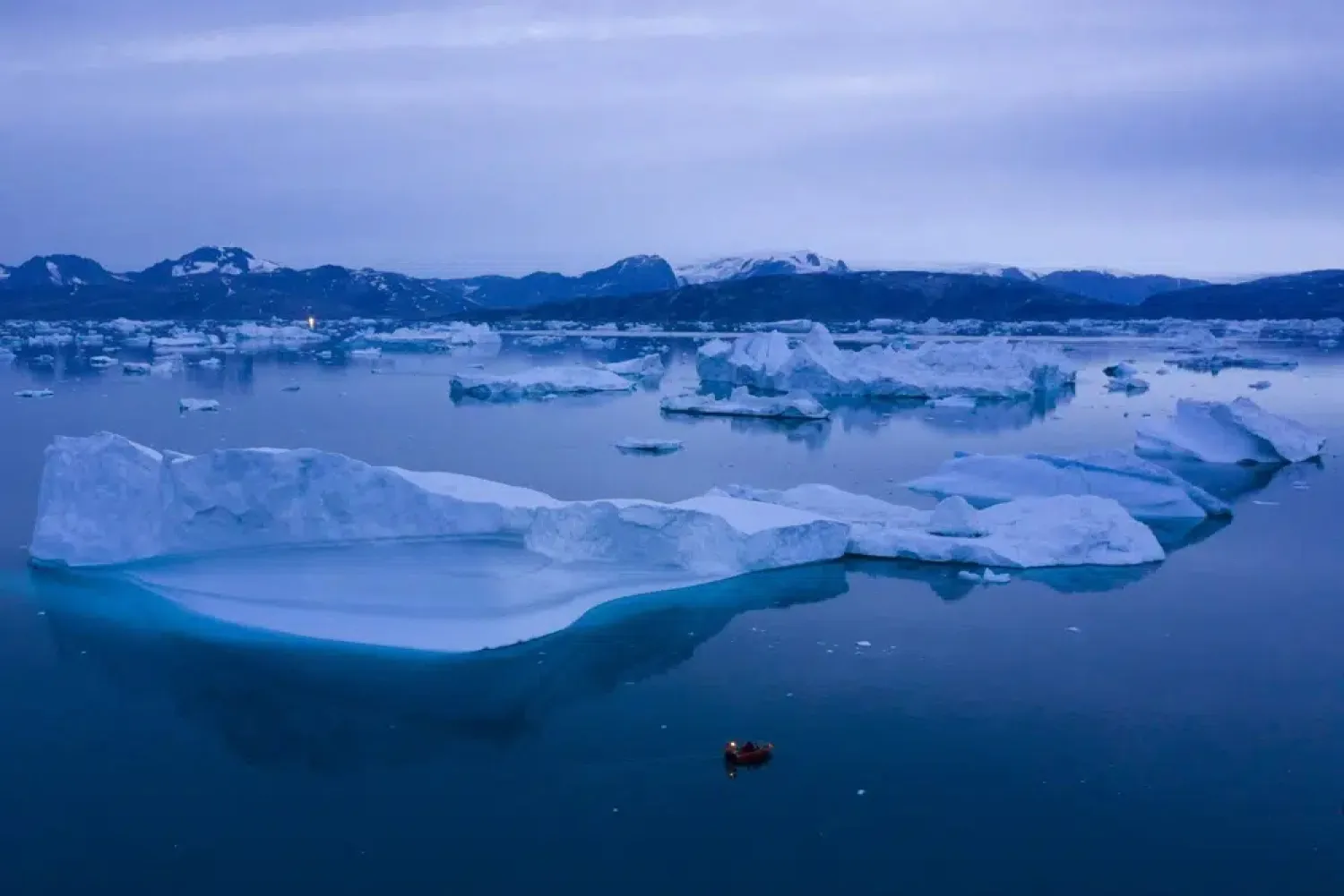FILE - A boat navigates at night next to large icebergs near the town of Kulusuk, in eastern Greenland on Aug. 15, 2019. (AP Photo/Felipe Dana, File)

