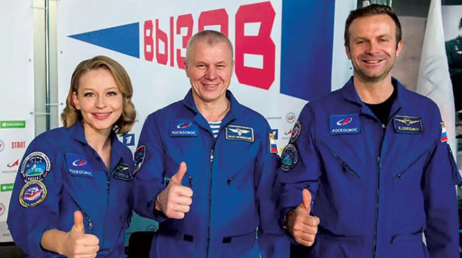 رائد الفضاء الروسي أوليج نوفيتسكي (وسط) والممثلة يوليا بيريسيلد والمخرج السينمائي كليم تشيبنكو بعد عودتهم من الفضاء (أ.ف.ب)