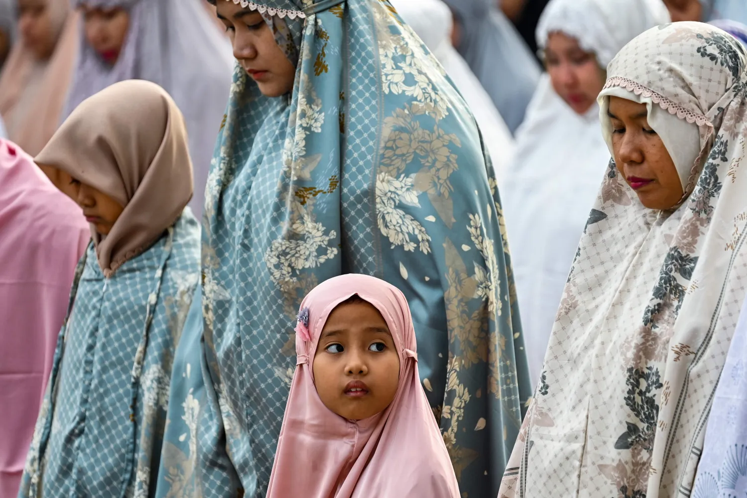 طفلة في صلاة عيد الفطر بإندونيسيا (أ.ف.ب)