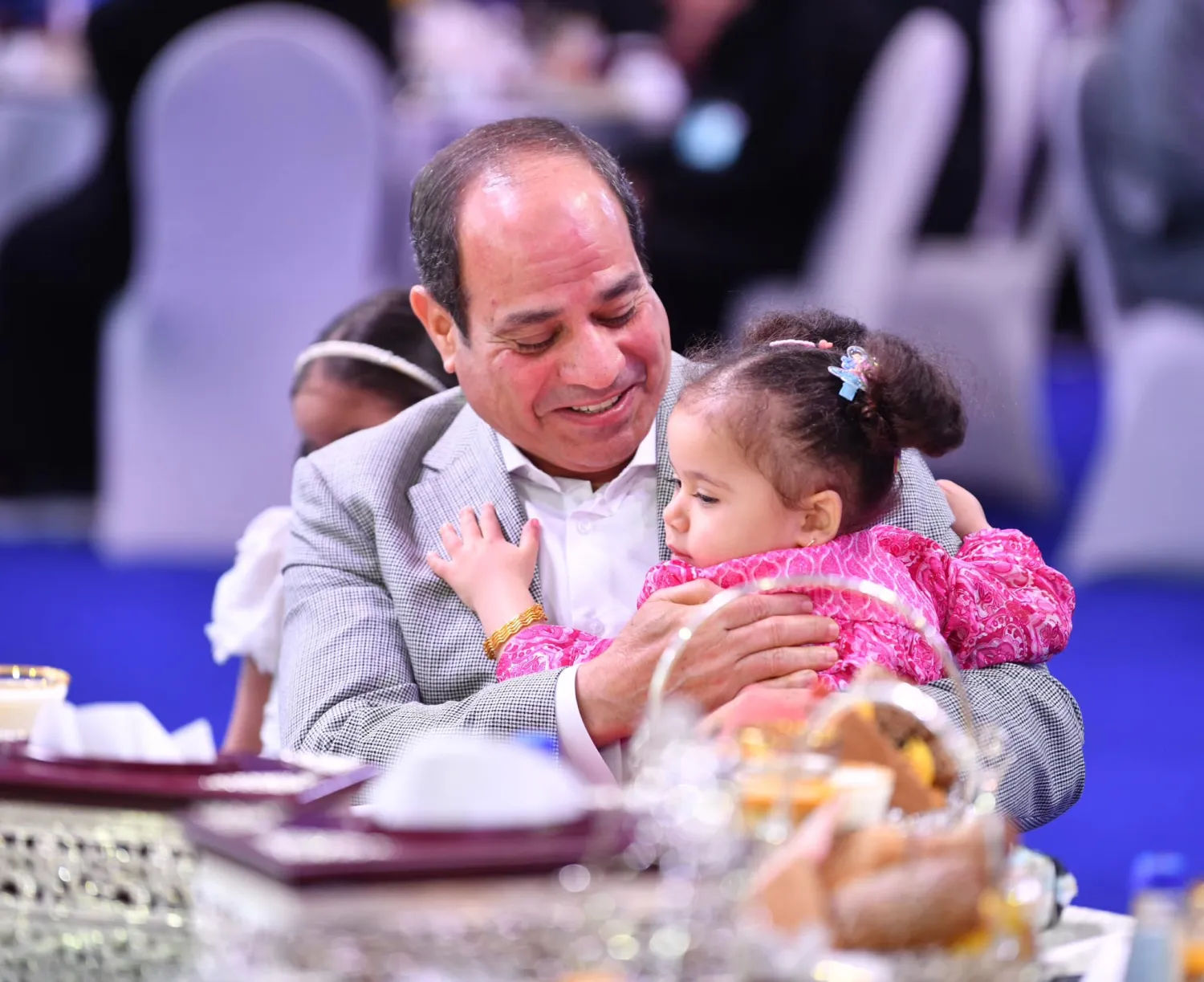 الرئيس المصري عبد الفتاح السيسي يحتضن ابنة أحد شهداء الجيش والشرطة في مصر خلال احتفالات عيد الفطر في القاهرة (الرئاسة المصرية)