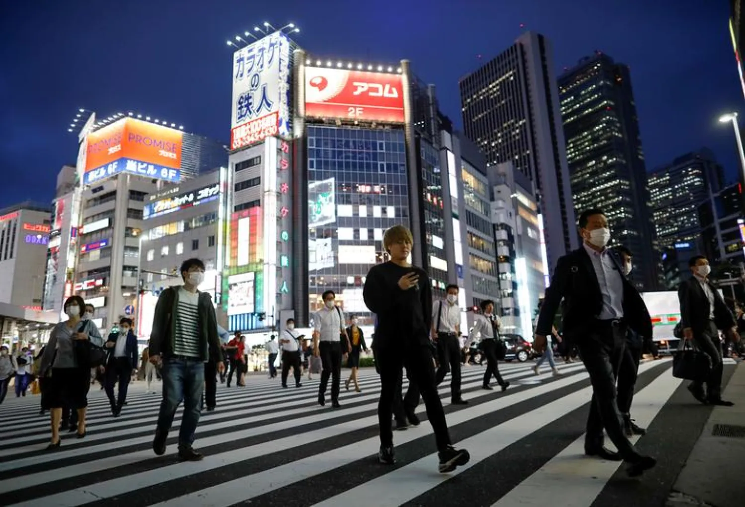 FILE PHOTO: Passersby walk on the crossing at Shinjuku district in Tokyo, Japan June 24, 2020. REUTERS/Issei Kato/File Photo
