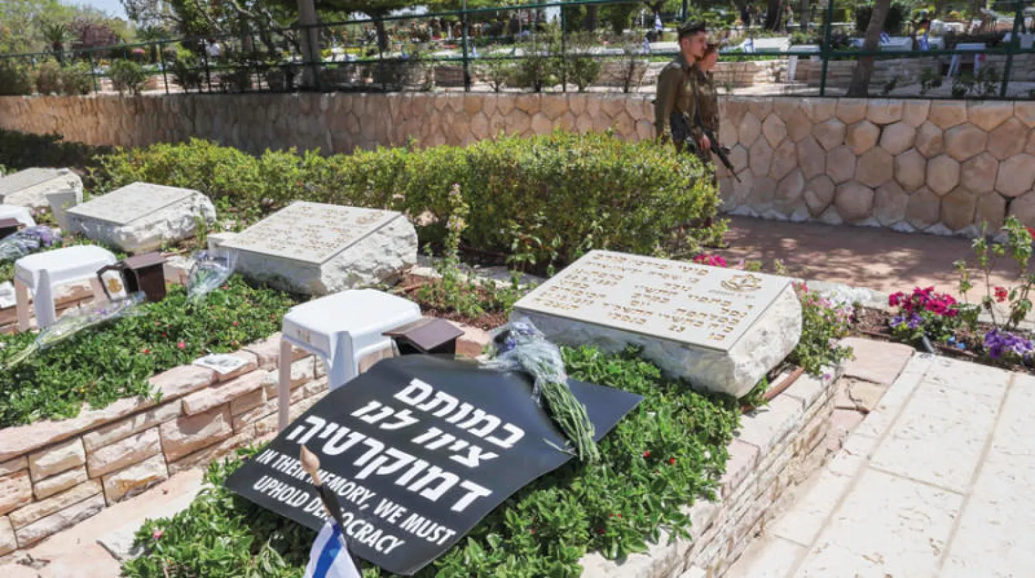 جنود اسرائيليون يمرون بالقرب من مقبرة كريات شاؤول العسكرية في تل ابيب (إ.ف.ب)