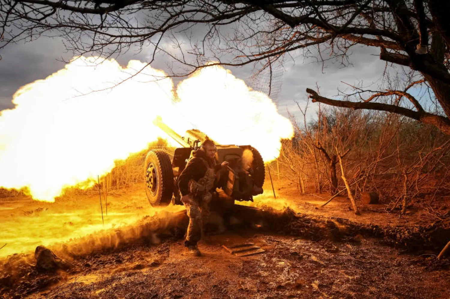 جندي أوكراني يطلق مدفعية (رويترز)