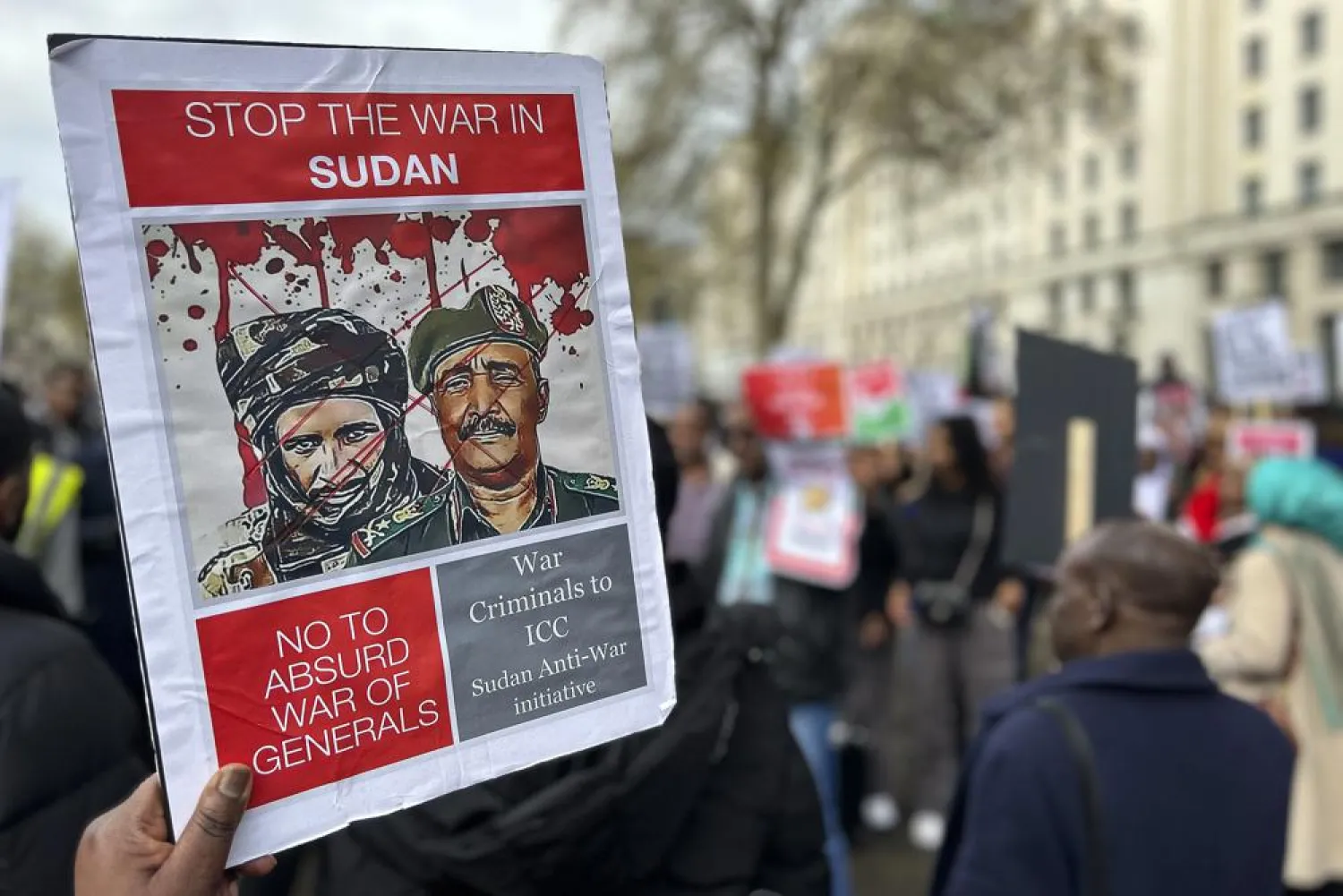 A demonstrator calling for the end of fighting in Sudan holds up a sign Sunday, April 23, 2023, outside Britain's Ministry of Defense in London. (AP Photo/Brian Melley)
