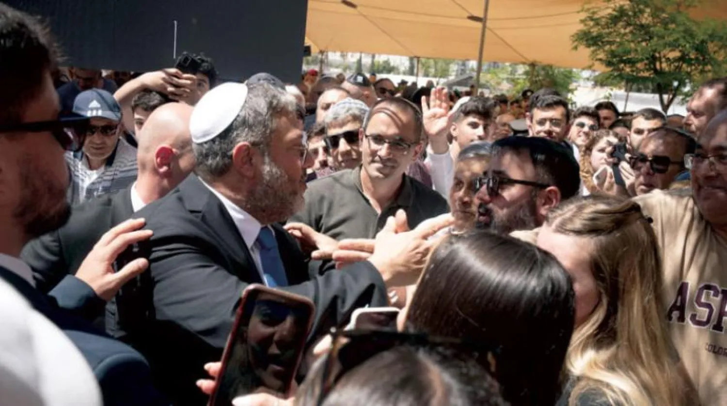 اتمار بن گویر ان لوگوں سے بات کر رہے ہیں جنہوں نے قبرستان میں ان کی موجودگی کو مسترد کیا تھا (اے پی)
