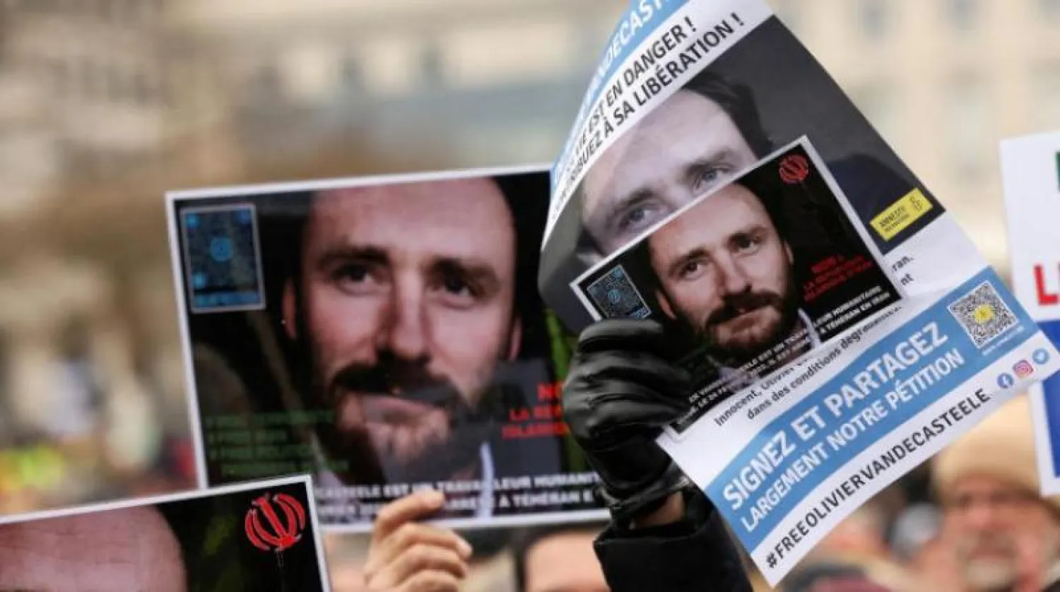 مواطنون يحملون صورة لعامل الإغاثة البلجيكي أوليفييه فانديكاستيل المحتجز في طهران خلال مسيرة تضامنية ببروكسل خلال يناير الماضي (أرشيفية - رويترز)