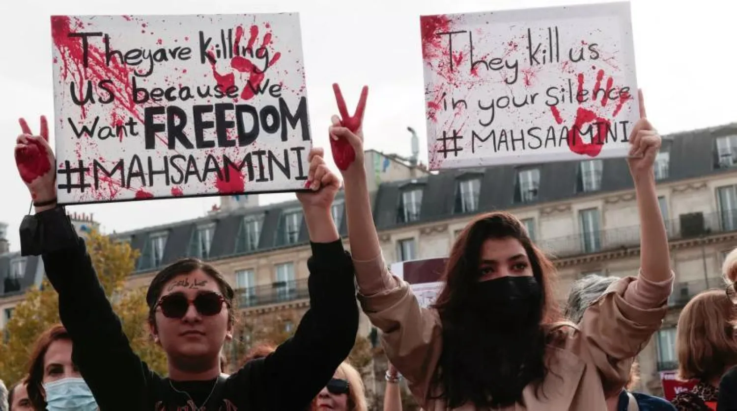 People hold up signs during a rally in support of the demonstrations in Iran at the Place de la République in Paris. (Geoffroy Van Der Hasselt/AFP/Getty Images)

