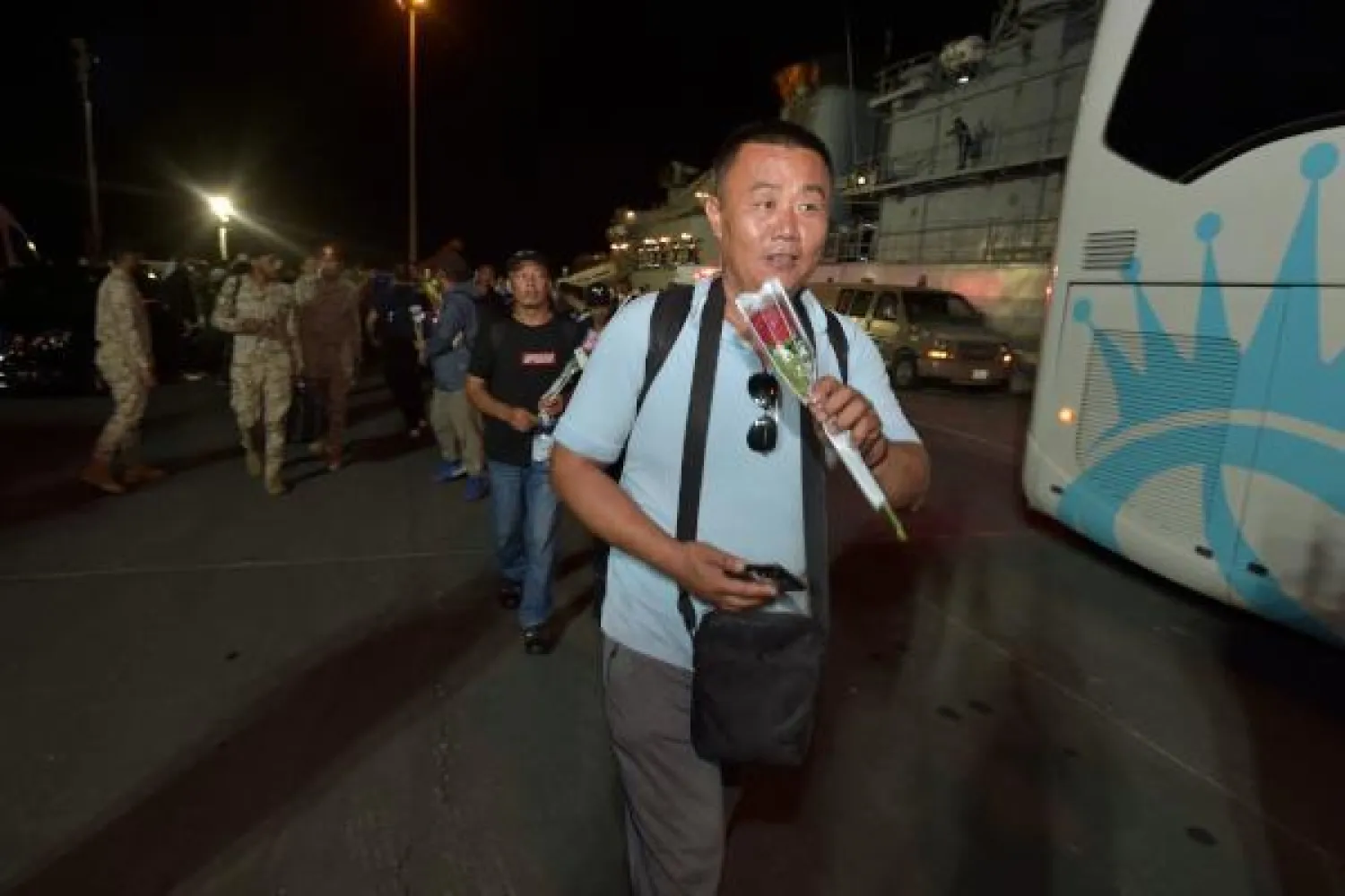 مواطنون صينيون تم إجلاؤهم من السودان لحظة وصولهم إلى قاعدة الملك فيصل البحرية في جدة يوم أمس (ا.ف.ب)