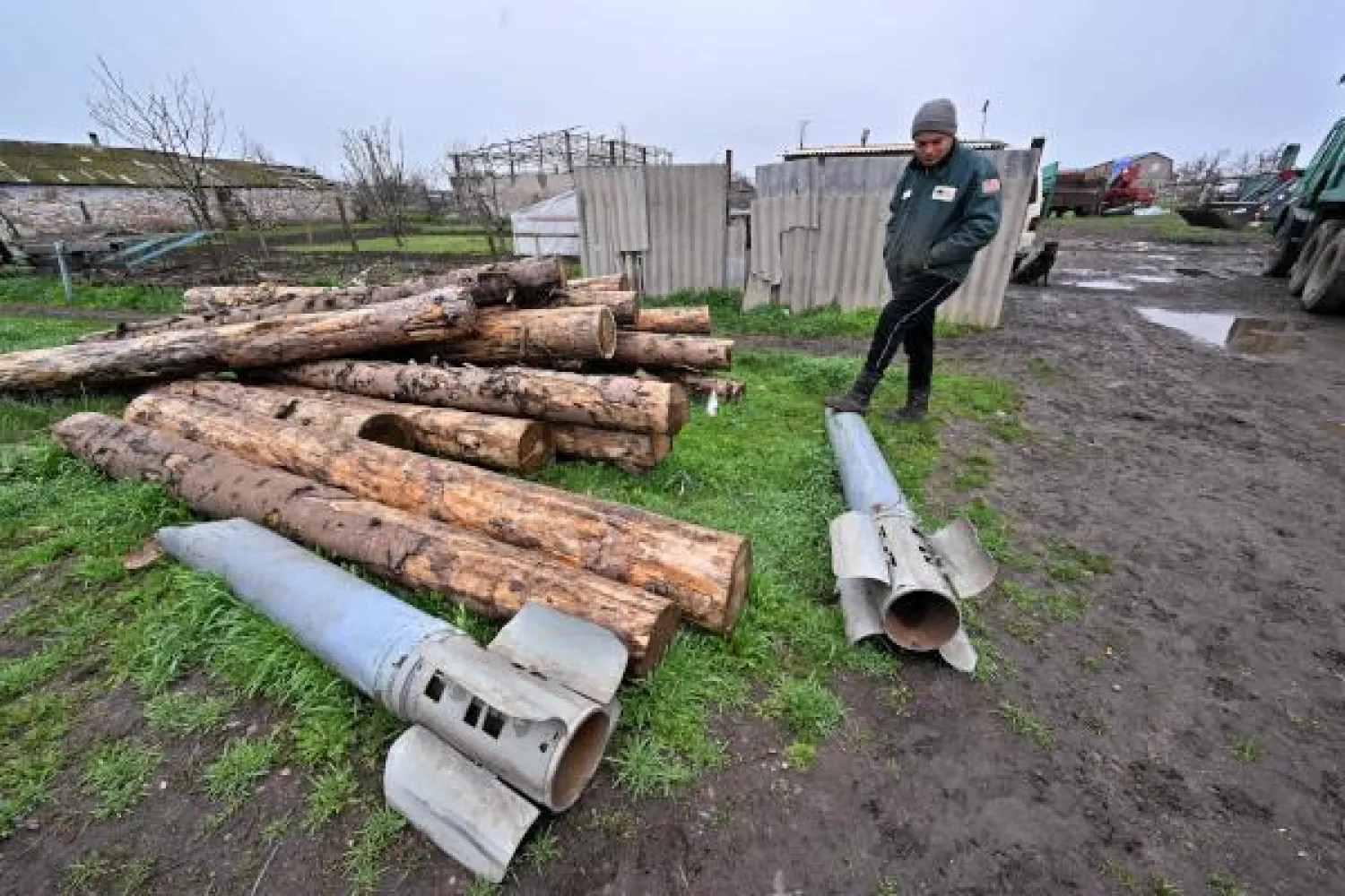 أرشيفية لمزارع أوكراني يقف بجوار بقايا صواريخ سقطت في مزرعته بمنطقة ميكولايف (ا.ف.ب)