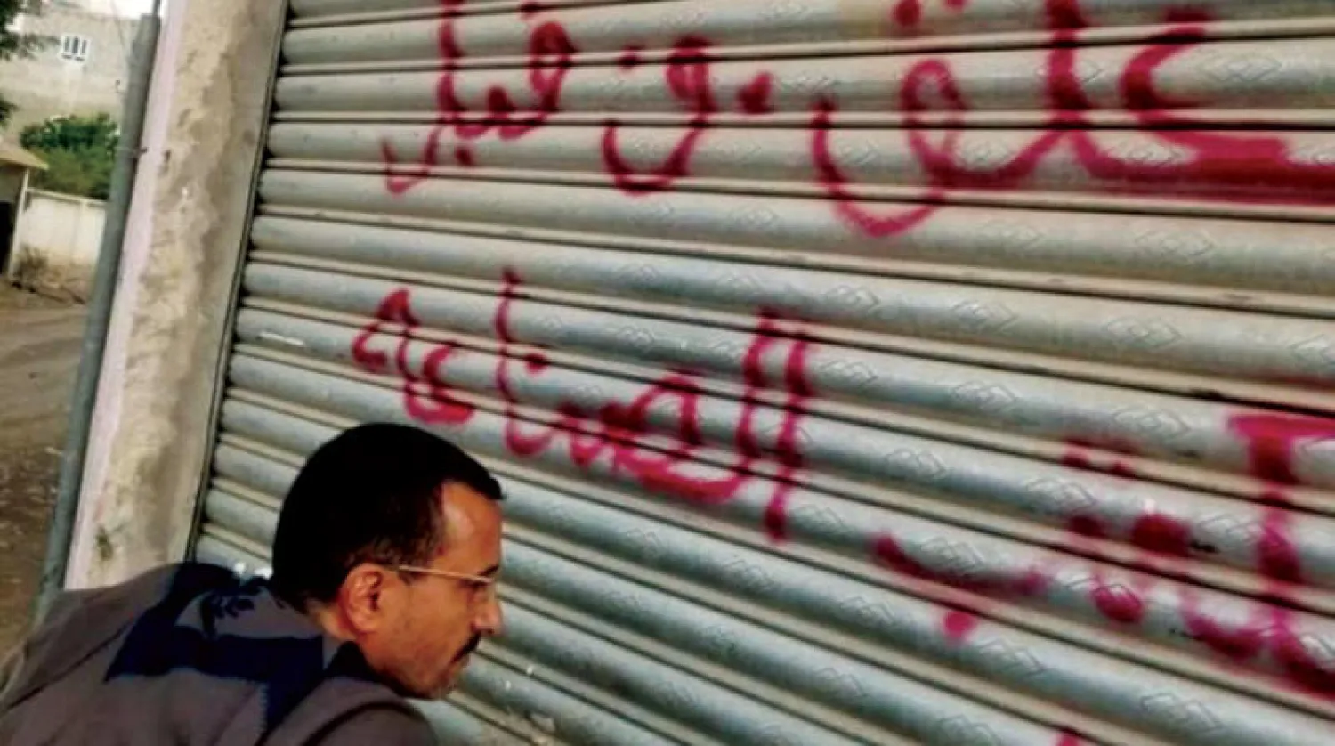 عنصر حوثي في صنعاء يغلق أحد المتاجر (إعلام حوثي)