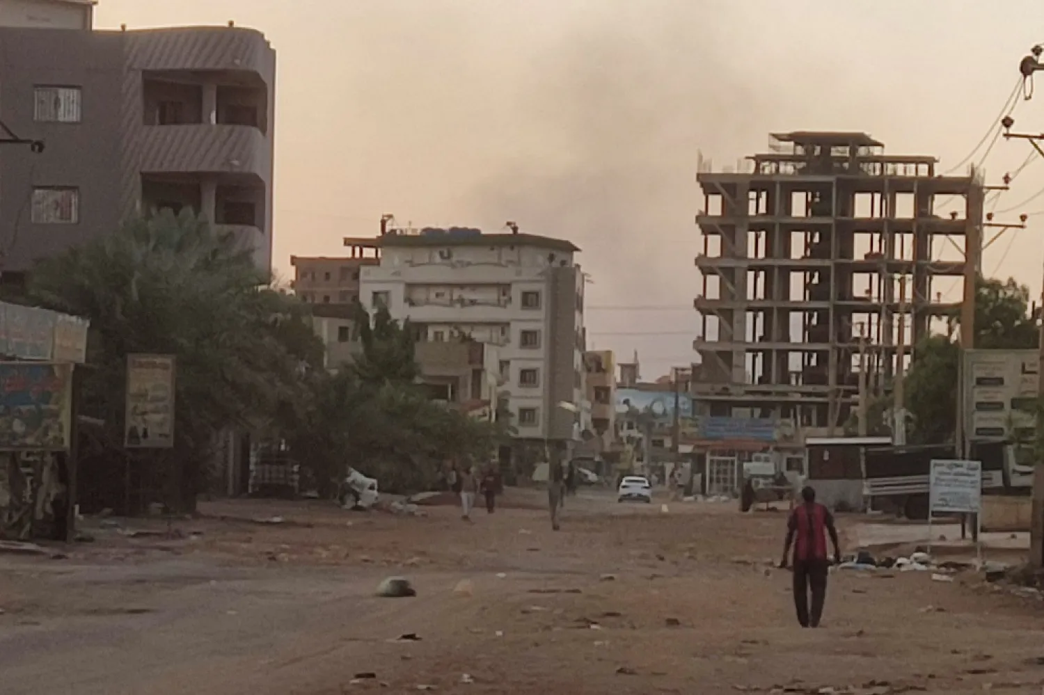 People walk on an almost empty street in southern Khartoum, on May 2, 2023. (AFP)