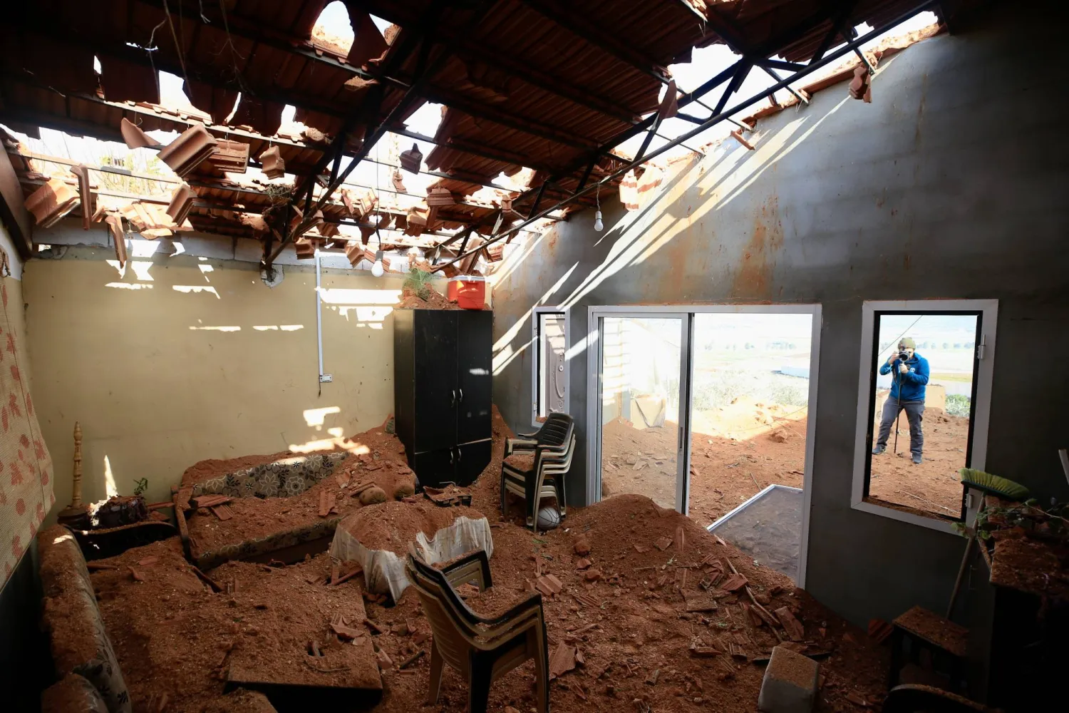 لبناني يتفقد منزلاً استهدفته غارة جوية إسرائيلية في بلدة كفركلا الحدودية (إ.ب.أ)