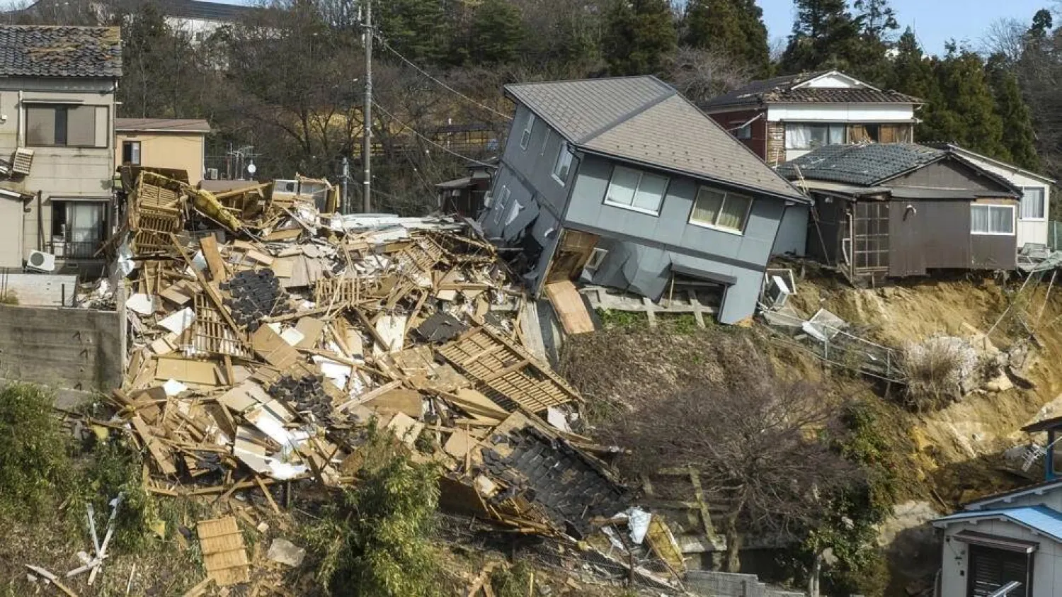 Damaged houses, including one totally collapsed (C), are pictured along a street in Wajima, Japan. Fred MERY / AFP