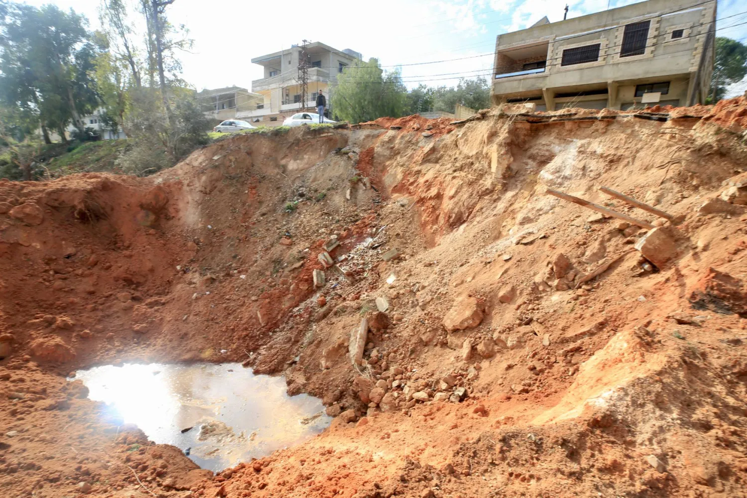 A man looks at a crater following an Israeli airstrike targeting Kfar Kila village on the border with Israel, in southern Lebanon, 31 December 2023. EPA/STR