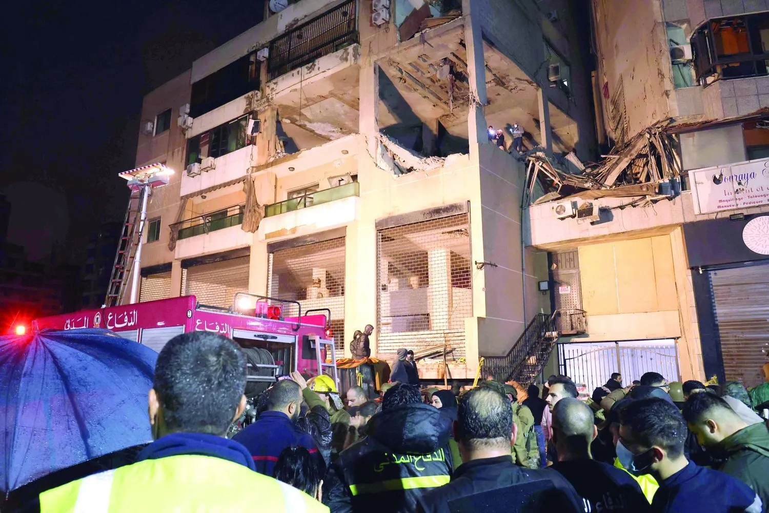 Dün Beyrut’un güney banliyösünde İsrail’in hedef aldığı Hamas ofis binası önünde Lübnan Sivil Savunma mensupları (AFP) ... Çerçevede saldırıda hayatını kaybeden Aruri’nin fotoğrafı var (EPA)