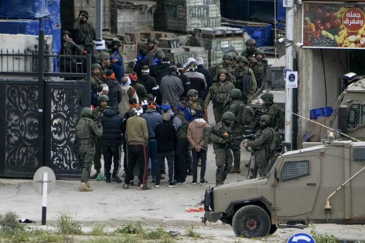 قوات أمن إسرائيلية توقف فلسطينيين في مخيم نور شمس بمحافظة طولكرم (أ.ب)