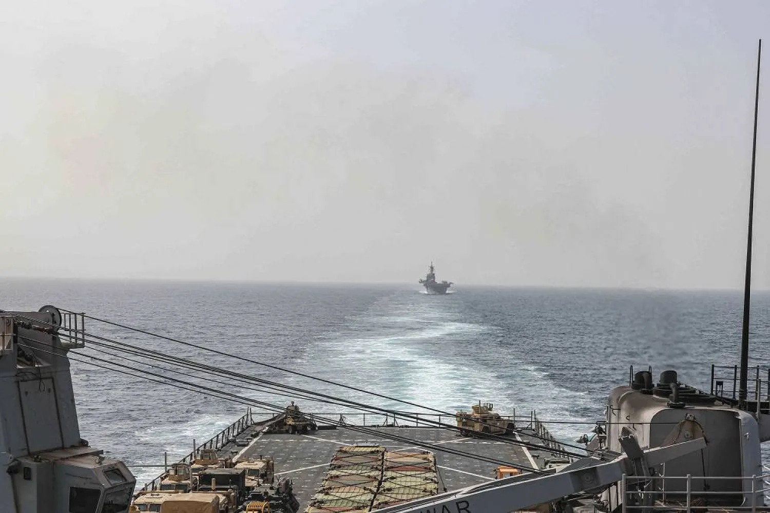 In this image provided by the US Navy, the amphibious dock landing ship USS Carter Hall and amphibious assault ship USS Bataan transit the Bab al-Mandeb strait on Aug. 9, 2023. (Mass Communications Spc. 2nd Class Moises Sandoval/US Navy via AP)