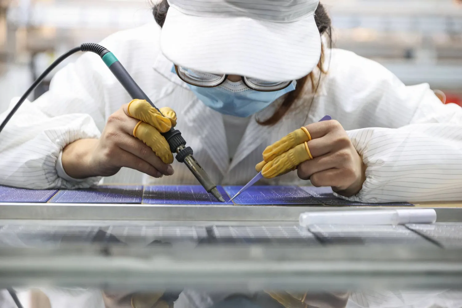 عامل في أحد مصانع إنتاج خلايا الطاقة الشمسية في مقاطعة جيانغزو شرق الصين (أ.ف.ب)