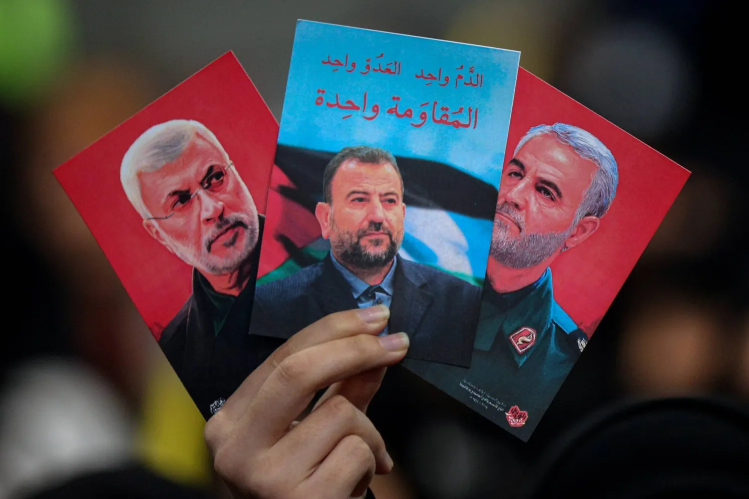 أنصار «حزب الله» اللبناني يرفعون صور أبو مهدي المهندس (يسار) نائب رئيس «الحشد الشعبي» العراقي ونائب زعيم «حماس» صالح العاروري (وسط) الذي قُتل في غارة جوية في بيروت وقائد فيلق القدس قاسم سليماني (د.ب.أ)