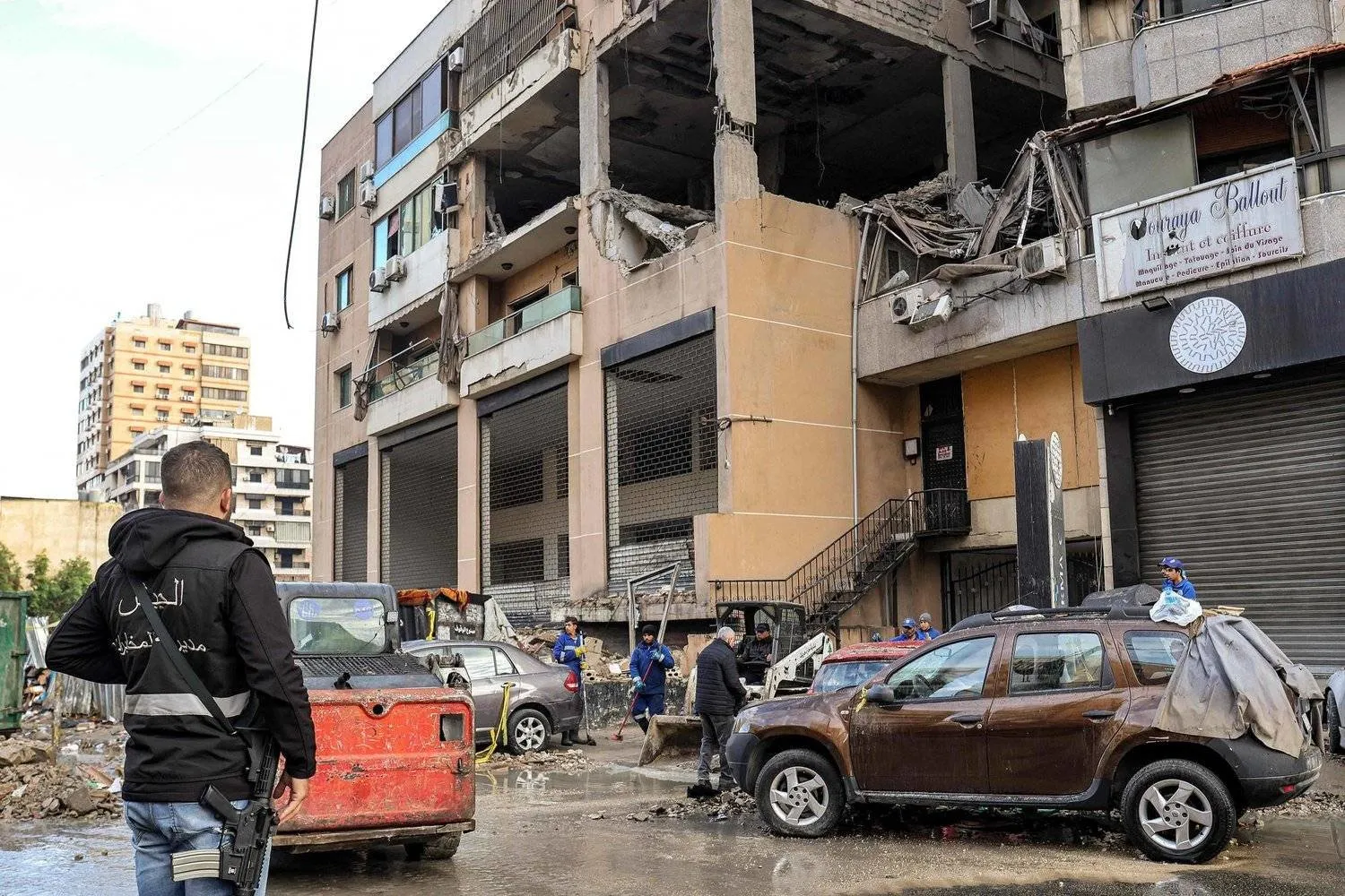 Lübnan Ordusu İstihbaratından bir üye, güney banliyösünde Aruri'nin hedef alındığı alanı temizleyen işçilerin yanında (AFP)