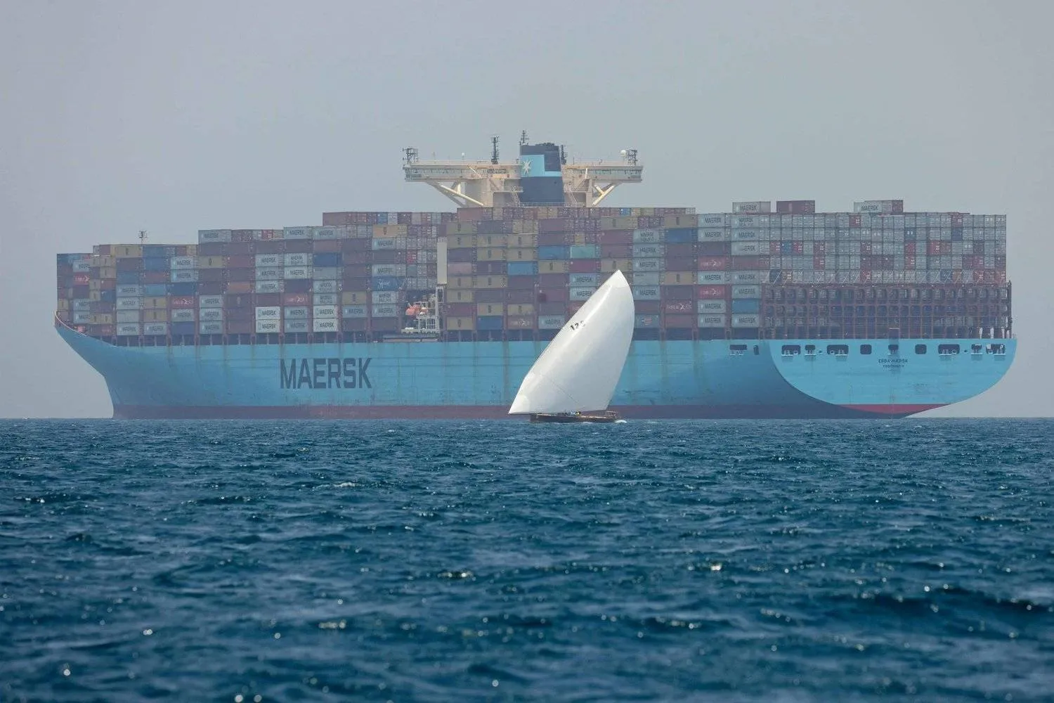 (FILES) Sailors pass by the Ebba Maersk container ship as they participate in the annual long-distance dhow sailing race, known as al-Gaffal, near Sir Abu Nuair island towards the Gulf emirate of Dubai on June 4, 2022. (Photo by Karim SAHIB / AFP)