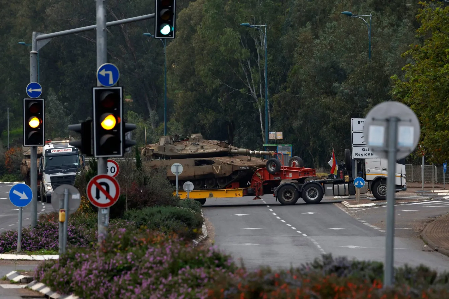 An Israeli military truck transports a tank in the Upper Galilee in northern Israel near the border with Lebanon on January 5, 2024. (Photo by jalaa marey / AFP)