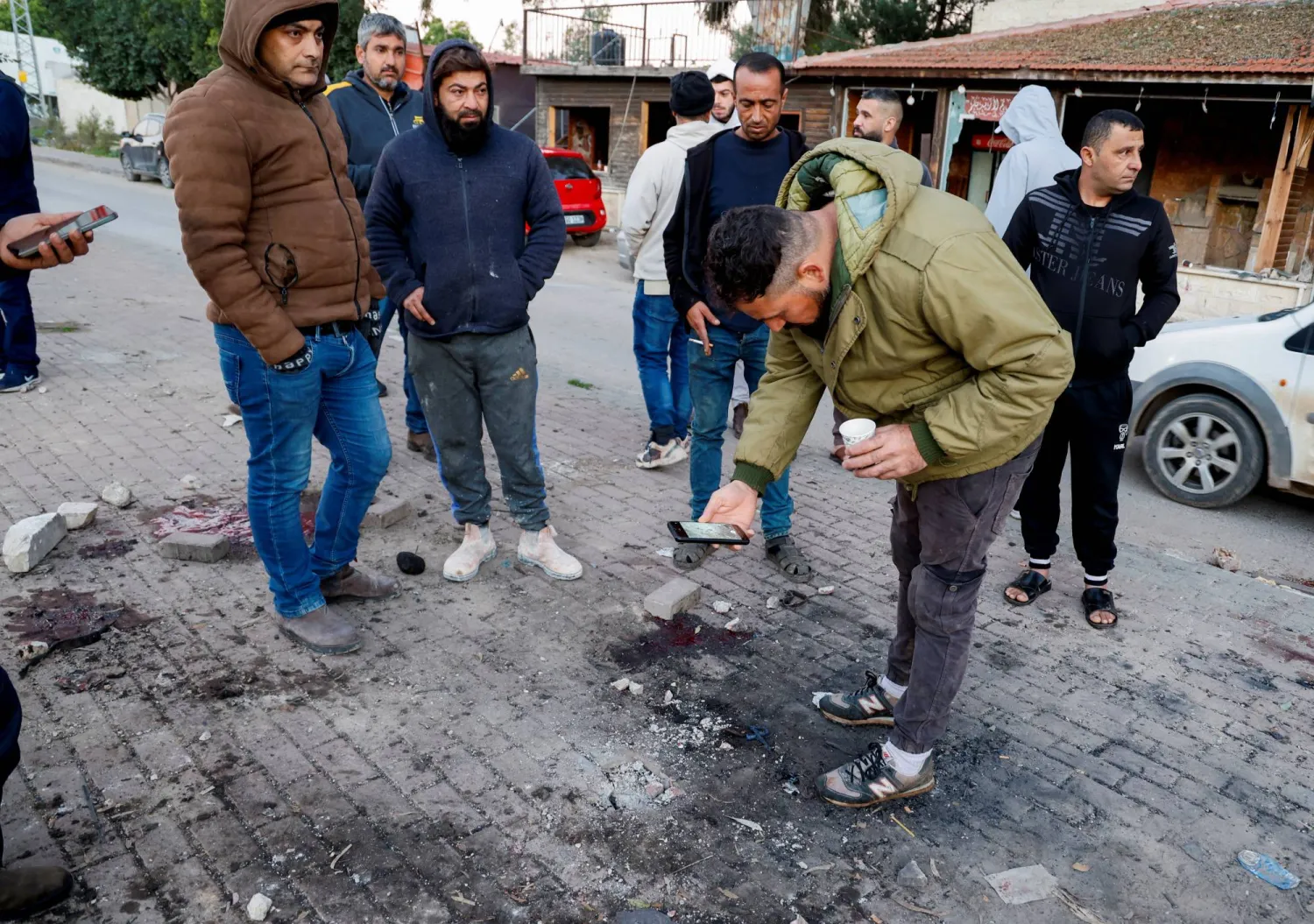 فلسطينيون يتفقدون الموقع الذي قتلت فيه غارة جوية إسرائيلية 6 رجال بالقرب من جنين في الضفة الغربية (رويترز)