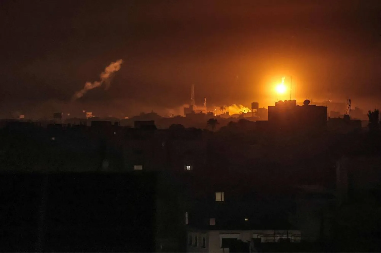 Israeli bombardment lights the skyline of Khan Younis, pictured from Rafah in the southern Gaza Strip late on January 7, 2024 amid the ongoing conflict between Israel and the Palestinian militant group Hamas. (AFP)