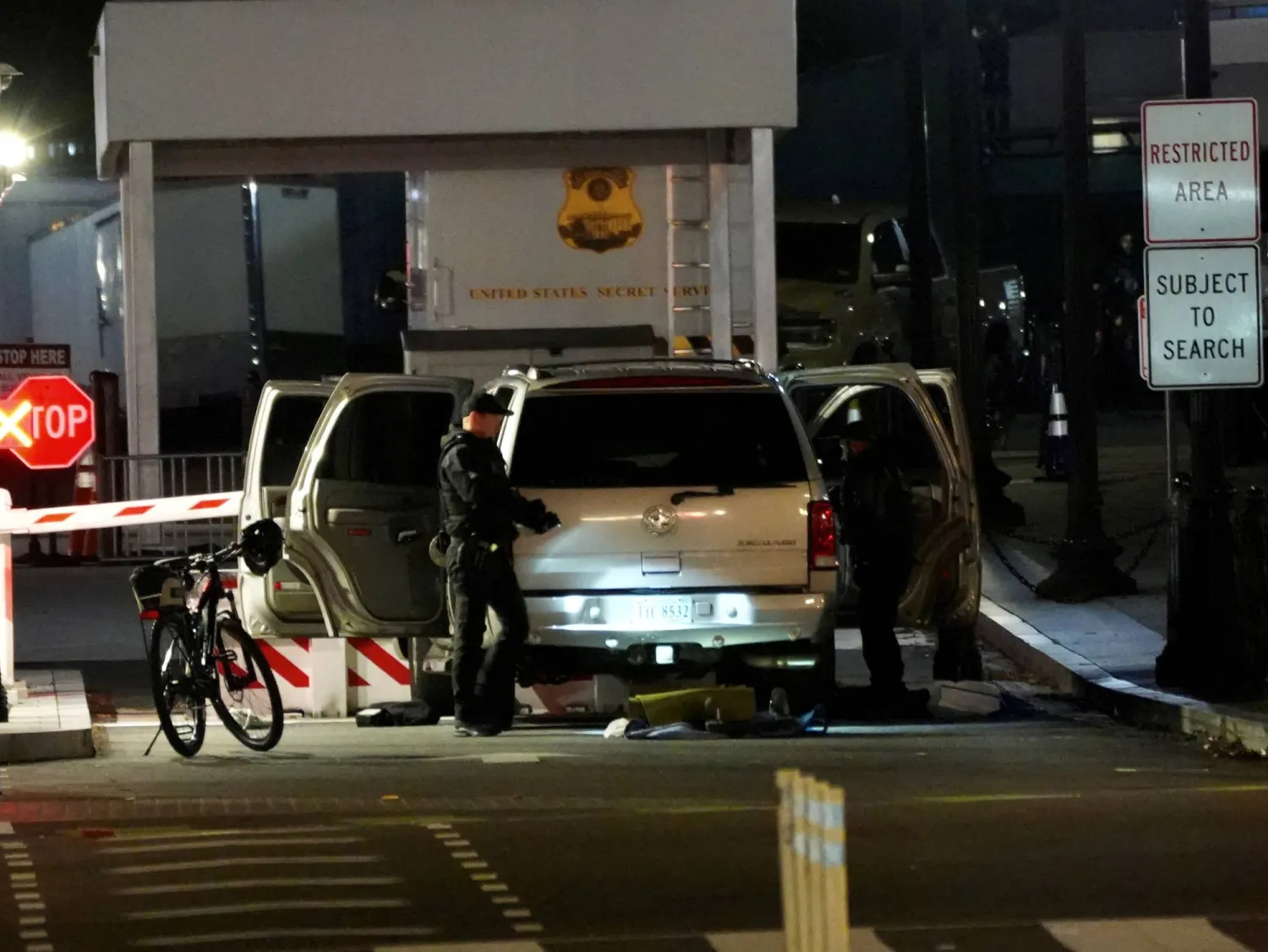 عناصر أمنية تقوم بتفتيش السيارة التي اصطدمت بسياج المقرّ الرئاسي في واشنطن (رويترز)