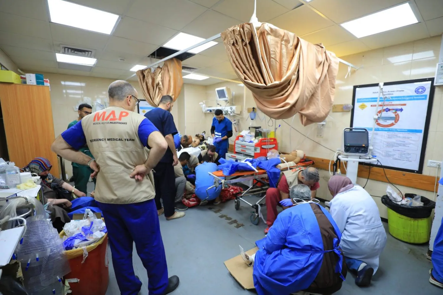 الدكتور نيك ماينارد وفريقه الطبي في مستشفى الأقصى (صورة من حساب منظمة «العون الطبي للفلسطينيين» على «تويتر»)