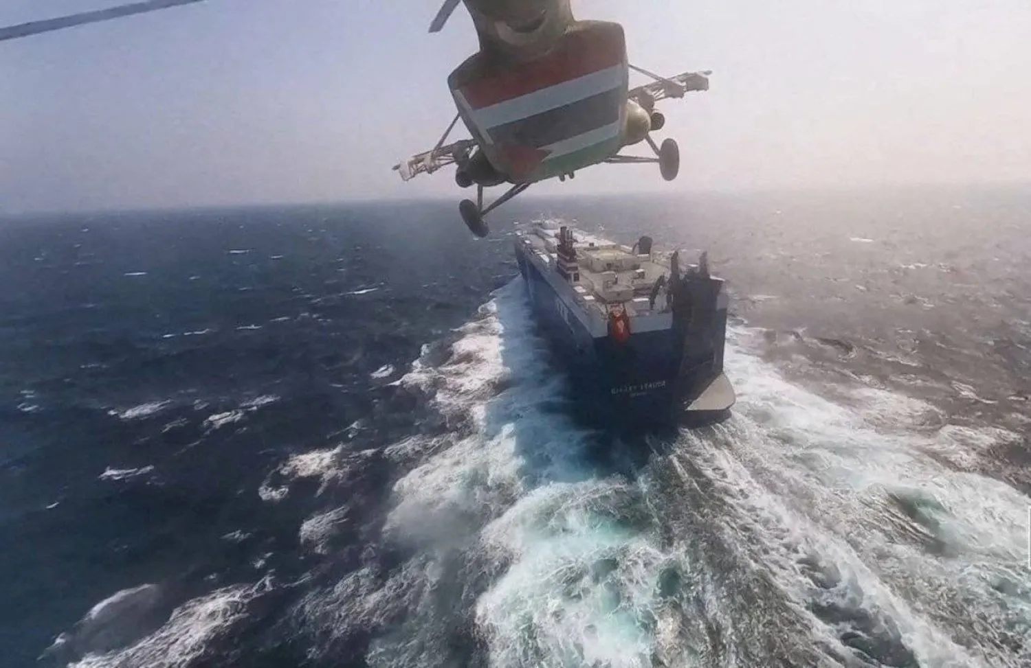 مروحية عسكرية تابعة للحوثيين تحلّق فوق سفينة شحن في البحر الأحمر (رويترز)