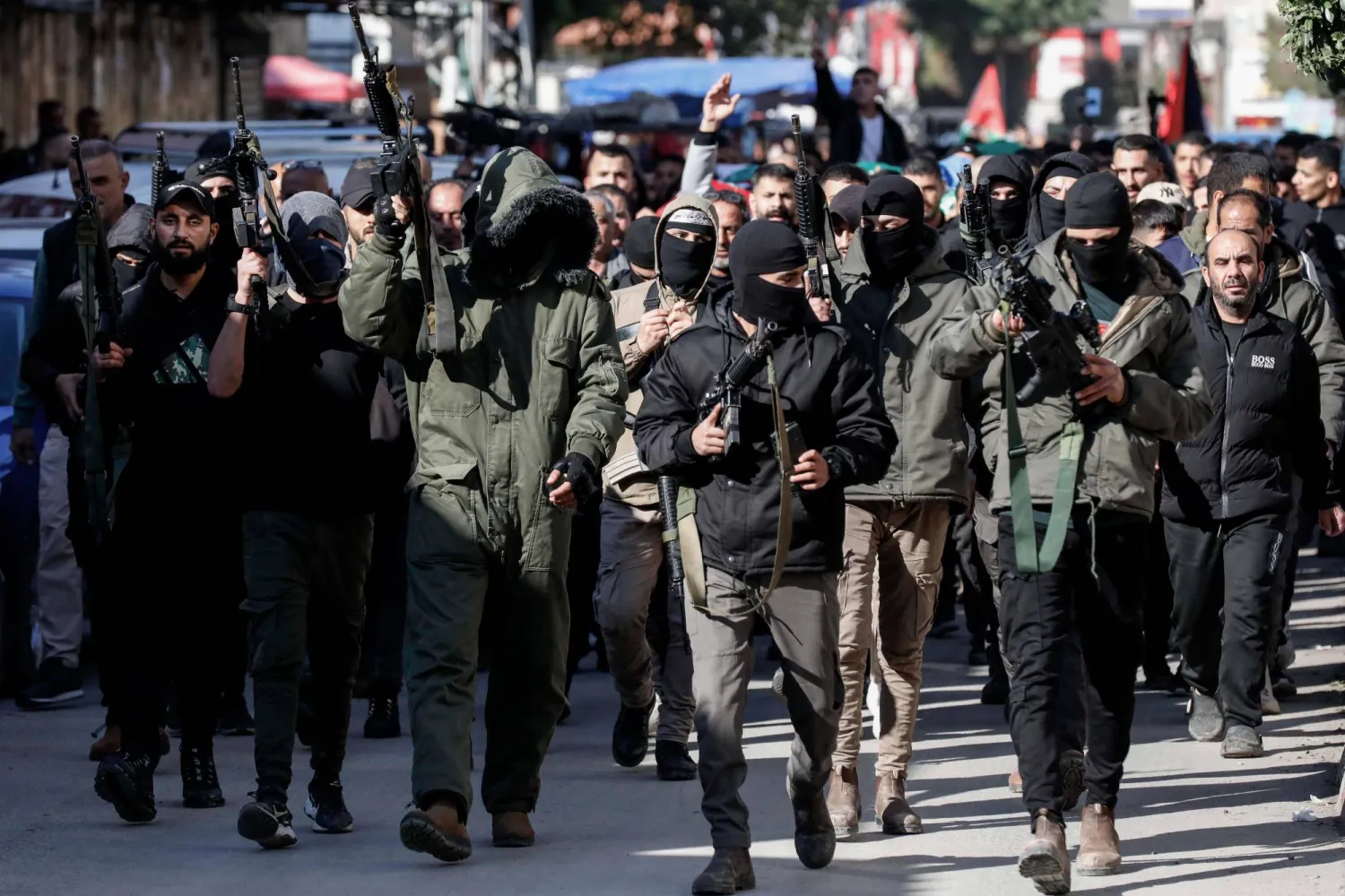 مسلحون يشاركون في تشييع فلسطينيين قتلوا في عملية للجيش الإسرائيلي بمدينة جنين (د.ب.أ)