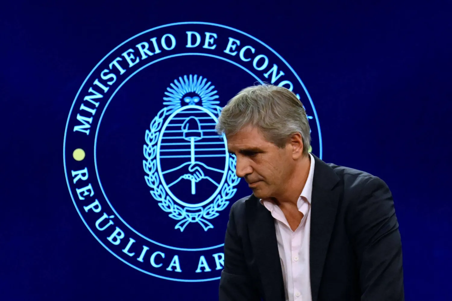 وزير الاقتصاد الأرجنتيني يهم بمغادرة القاعة بعد عقده مؤتمراً صحافياً شرح فيه تفاصيل الاتفاق مع صندوق النقد الدولي (أ.ف.ب)