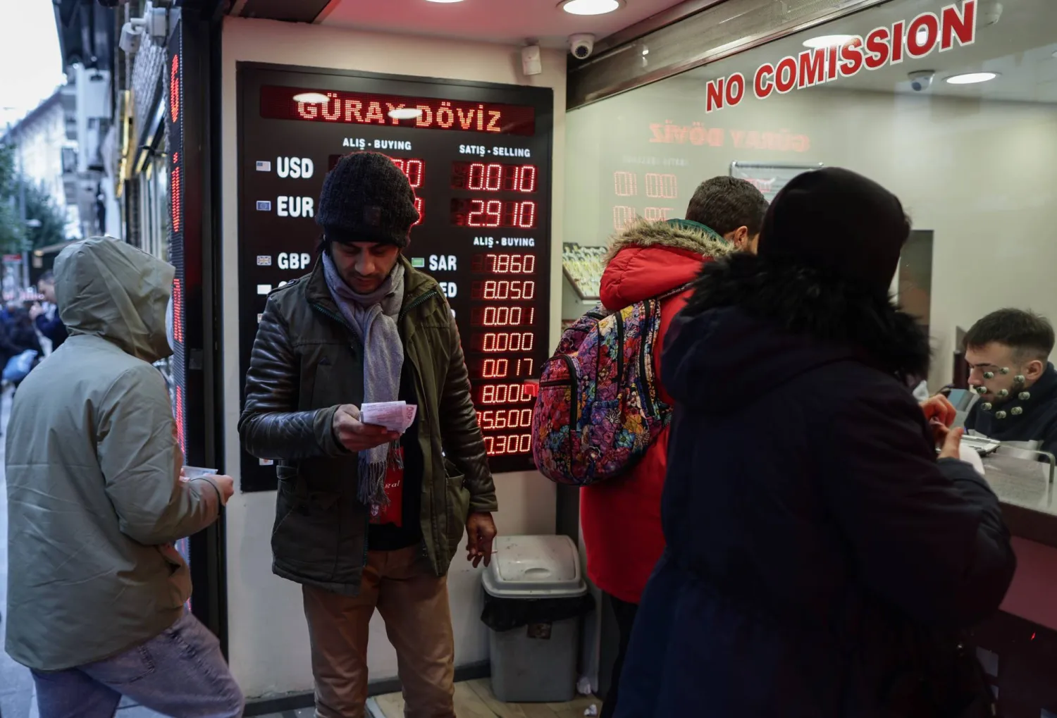 متعاملون بمكتب لصرف العملات في إسطنبول بعدما سجلت الليرة التركية مستوى قياسياً منخفضاً أمام الدولار (إ.ب.أ)