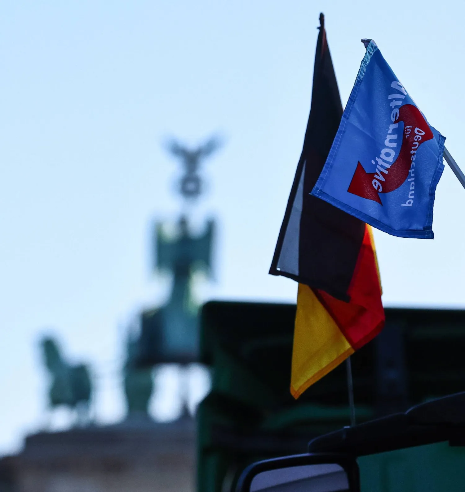 علم حزب «البديل لألمانيا» مرفوع خلال مظاهرة للمزارعين اعتراضاً على سياسات الحكومة بالقرب من بوابة براندبيرغ (إ.ب.أ)