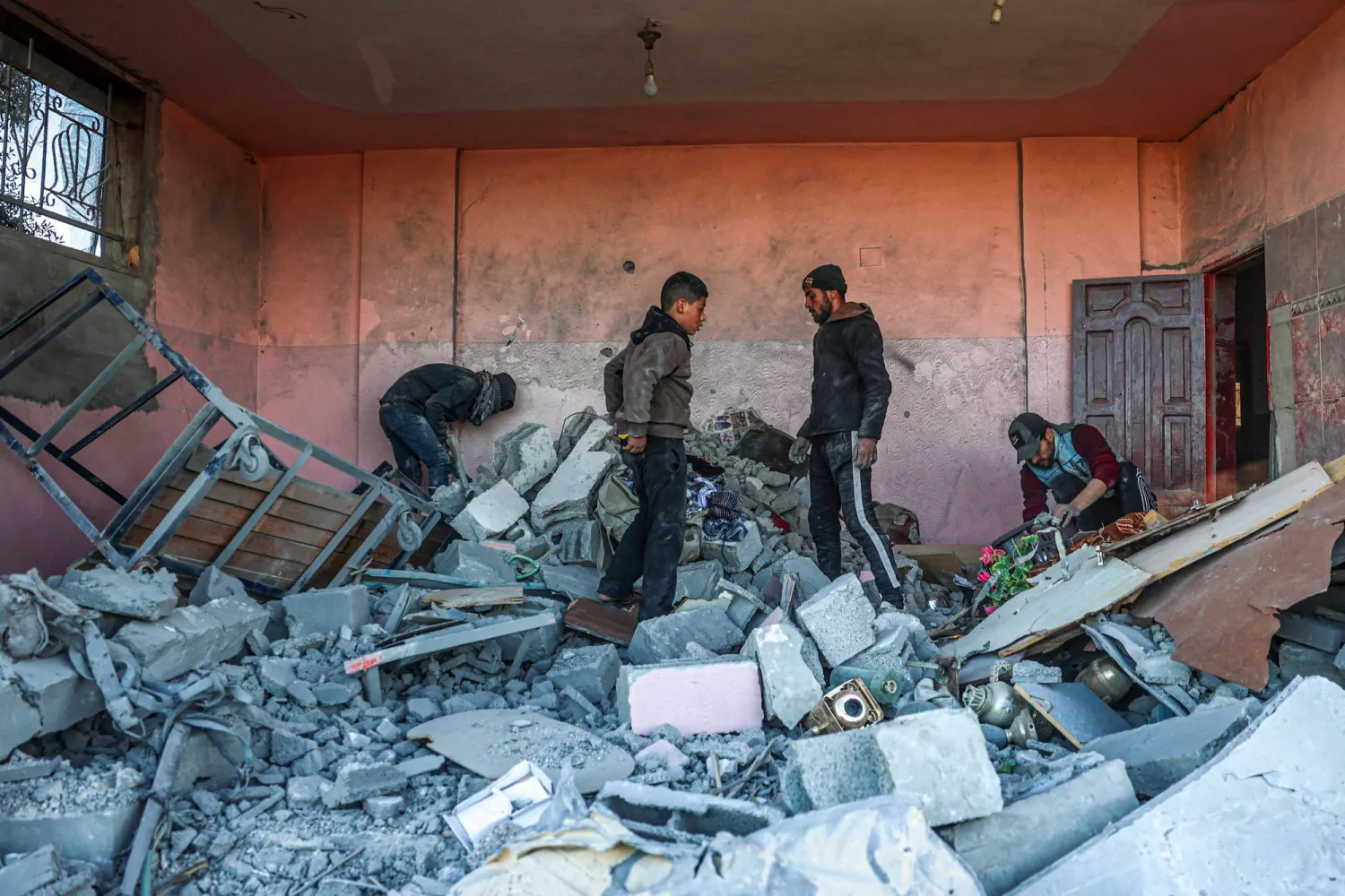 مواطنون يبحثون في أنقاض أحد المنازل المهدمة بفعل القصف الإسرائيلي في رفح (أ.ف.ب)