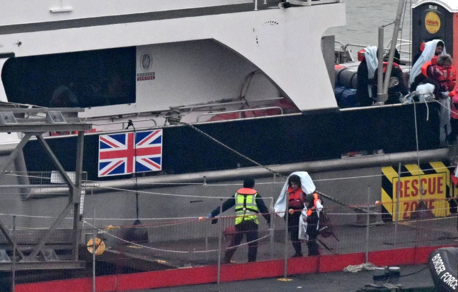 Migrants with children, some of the first in 2024 to be picked up at sea attempting to cross the English Channel from France, disembark from the UK Border Force Cutter 'Typhoon', at the Marina in Dover southeast England, on January 13, 2024. (Photo by Glyn KIRK / AFP)