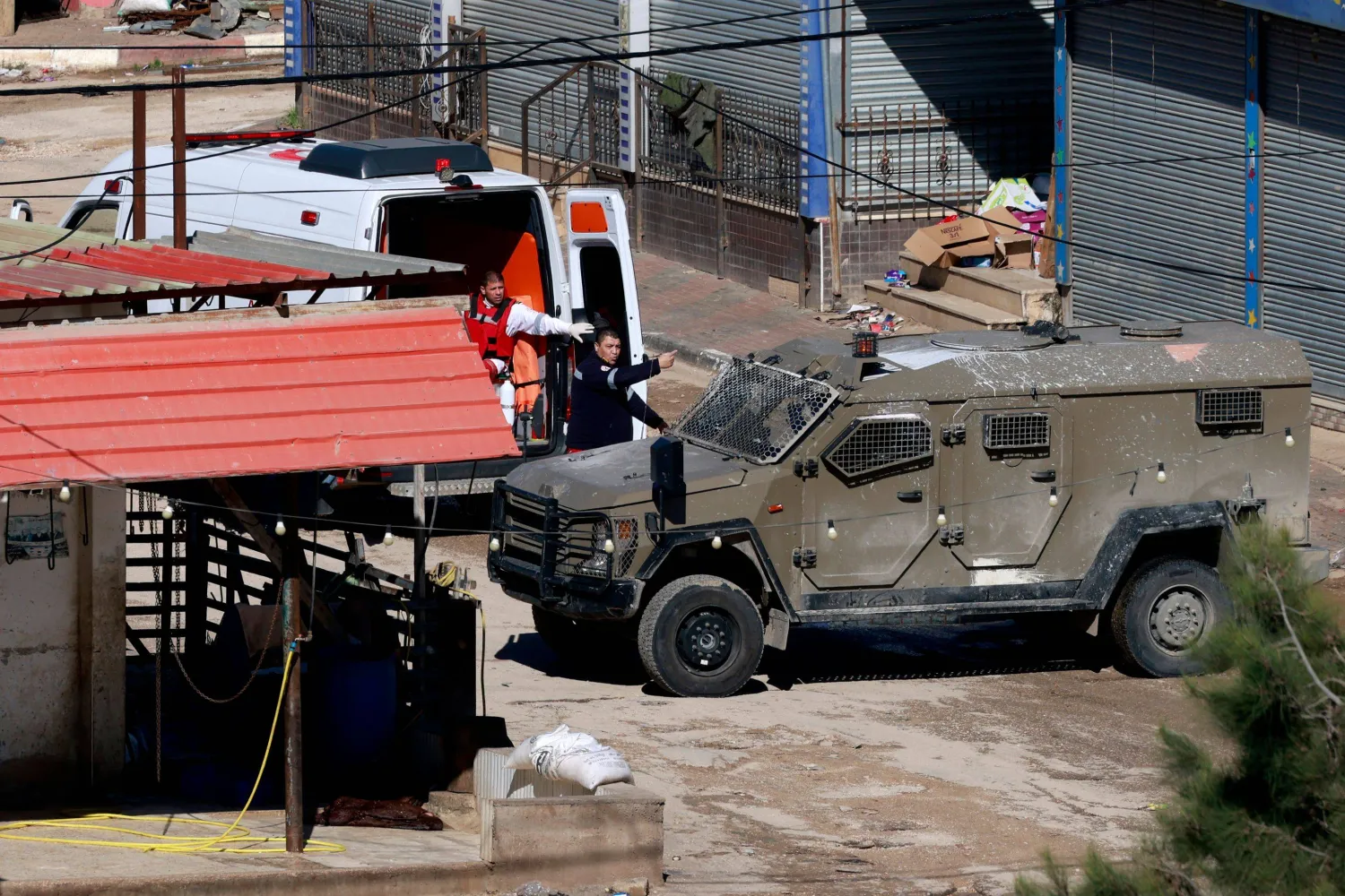 سيارة تابعة للقوات الإسرائيلية تغلق الطريق خلال وصول سيارة إسعاف تابعة لـ«الهلال الأحمر الفلسطيني» خلال مداهمة مخيم الفارعة للاجئين الفلسطينيين بالقرب من مدينة طوباس في الضفة الغربية (أ.ف.ب)