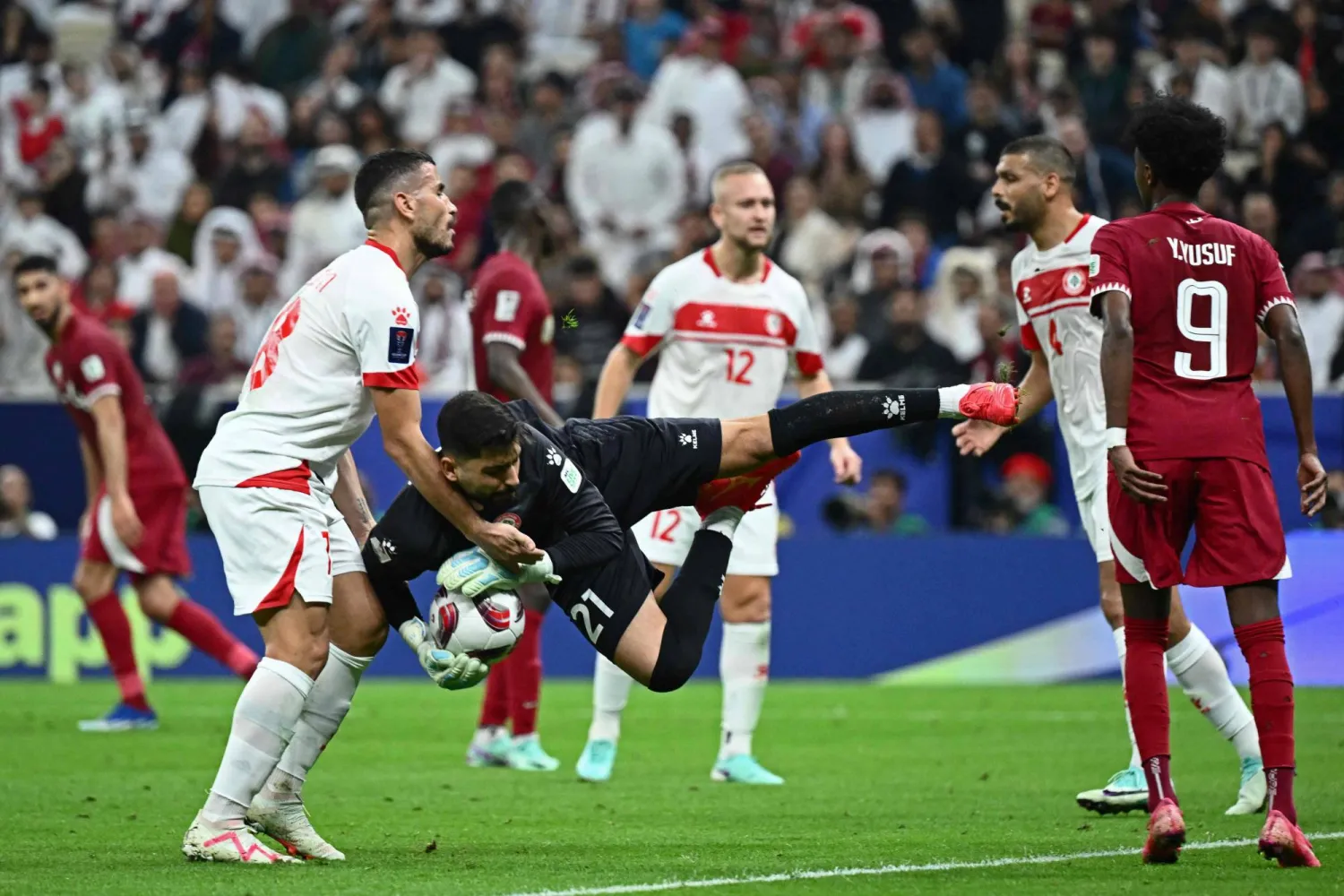 حارس لبنان أثناء صده إحدى تسديدات المنتخب القطري (أ.ف.ب)