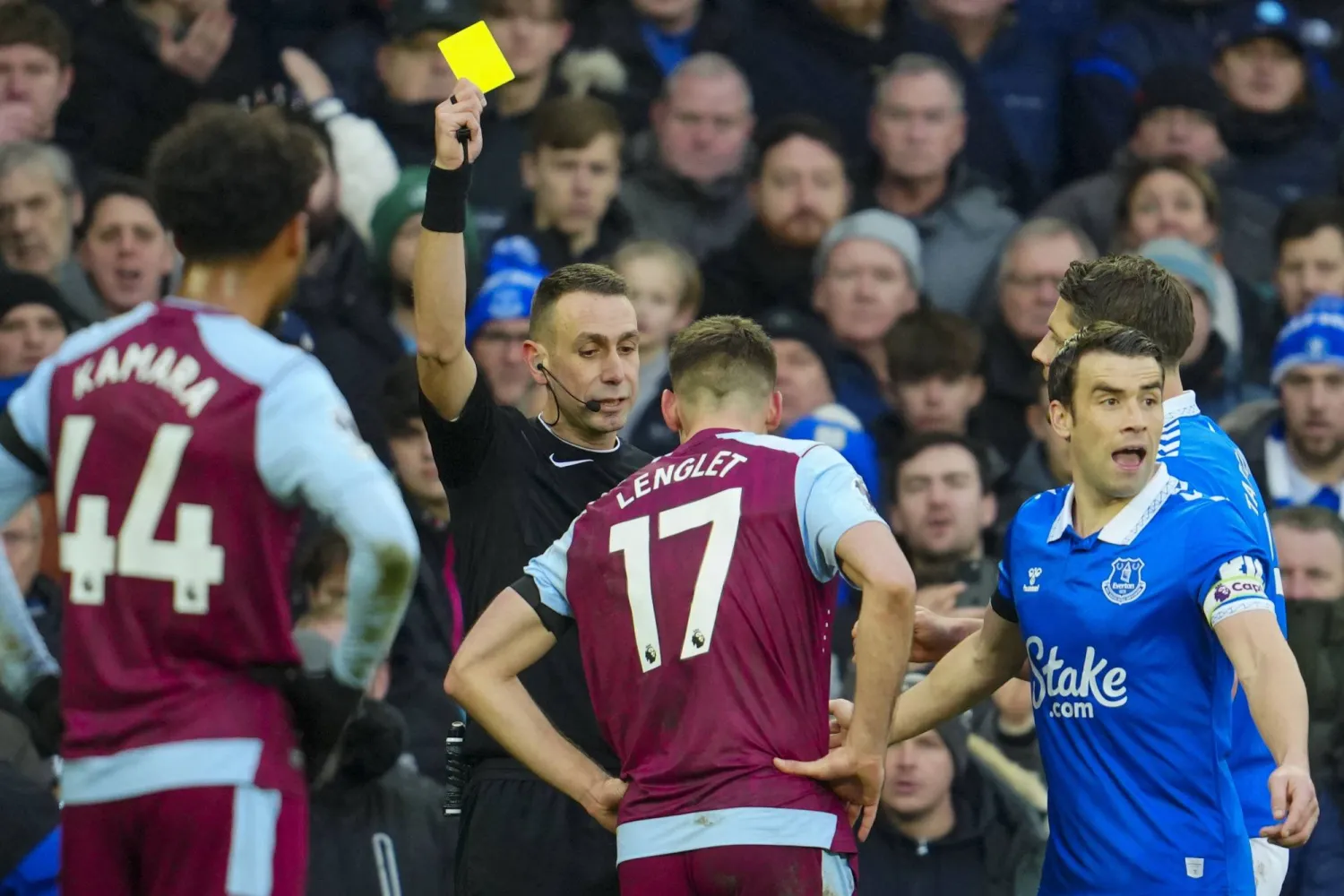 الحكم ديفيد كوت يشهر بطاقة صفراء لكليمنت لينغليت لاعب أستون فيلا (أ.ب)