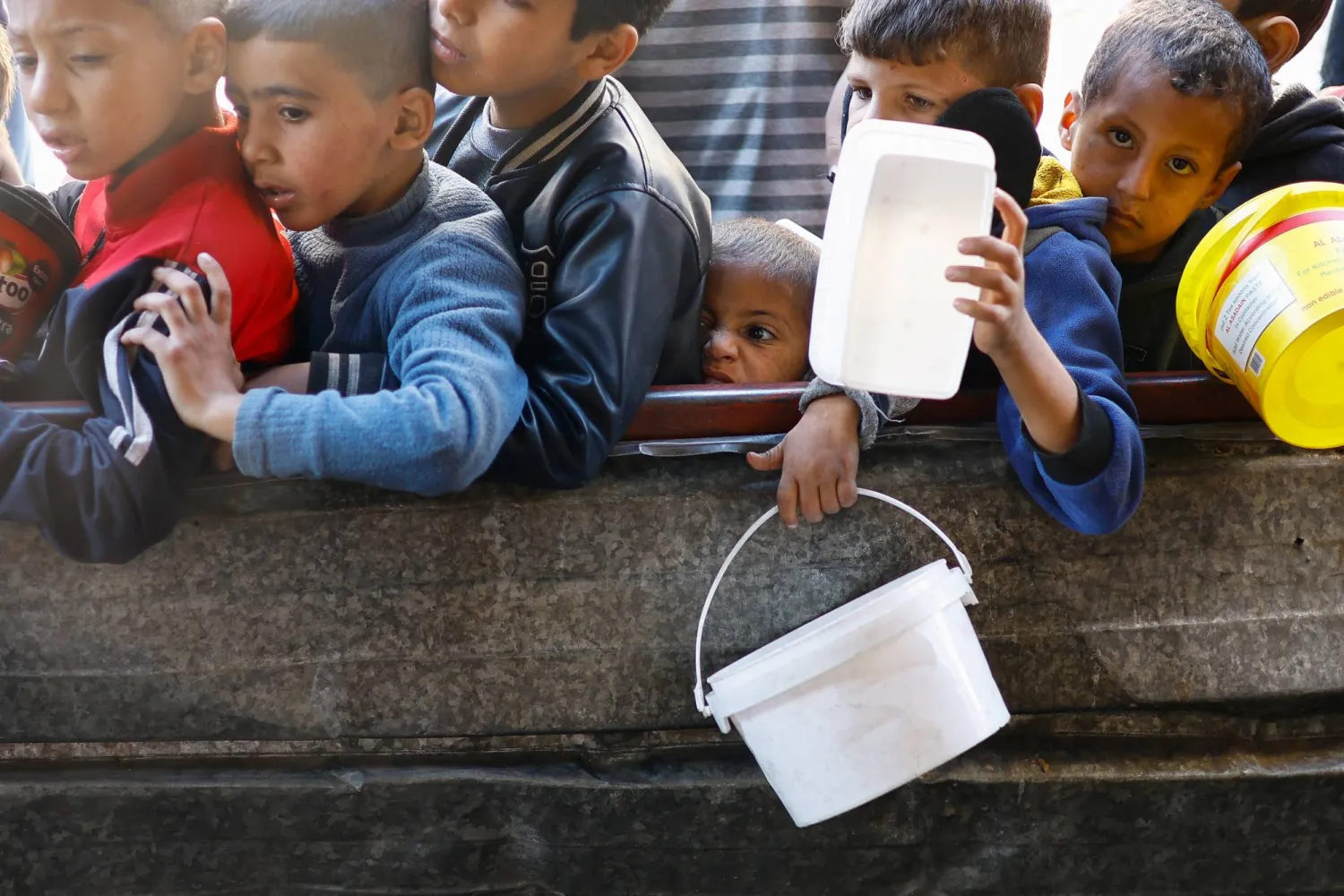 أطفال فلسطينيون ينتظرون دورهم للحصول على الطعام في رفح جنوب قطاع غزة (رويترز)
 