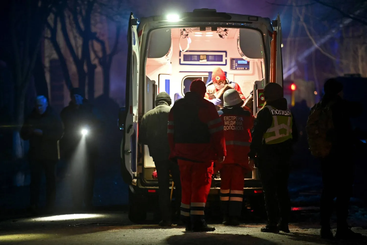 طاقم طبي يقدم المساعدة لأحد السكان المحليين الذين أُصيبوا نتيجة هجوم صاروخي في خاركيف (أ.ف.ب)