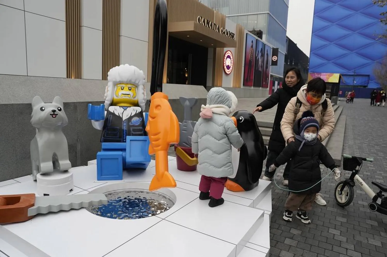 Children play near a display depicting an elderly person at a shopping mall in Beijing, Wednesday, Jan. 17, 2024. (AP)