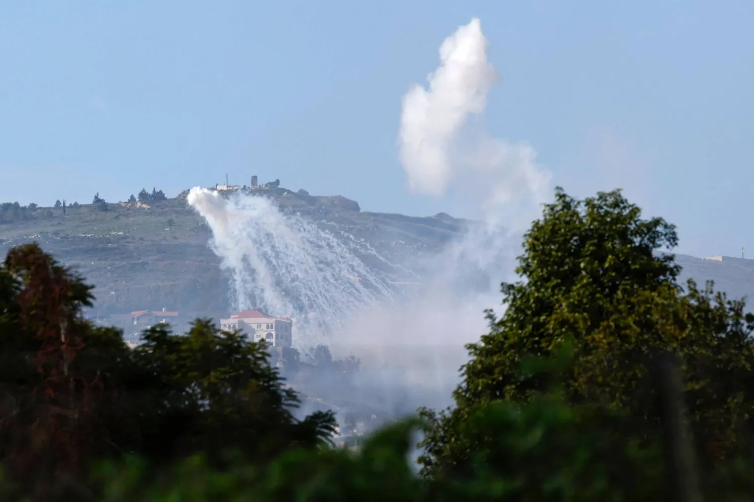 دخان يتصاعد فوق قرية العديسة اللبنانية في أثناء القصف الإسرائيلي (أ.ف.ب)